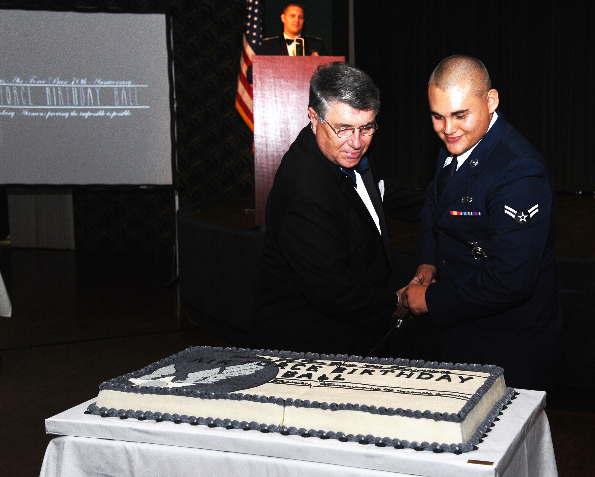 Retired Gen. Paul Hester and Airman 1st Class Jason Laufer, 14th Civil Engineering Squadron keep with tradition by cutting the Air Force Birthday Ball birthday cake.  Traditionally, the birthday cake is cut by the oldest and youngest service members in attendance.  (U.S. Air Force Photo/Airman 1st Class Charles Dickens)