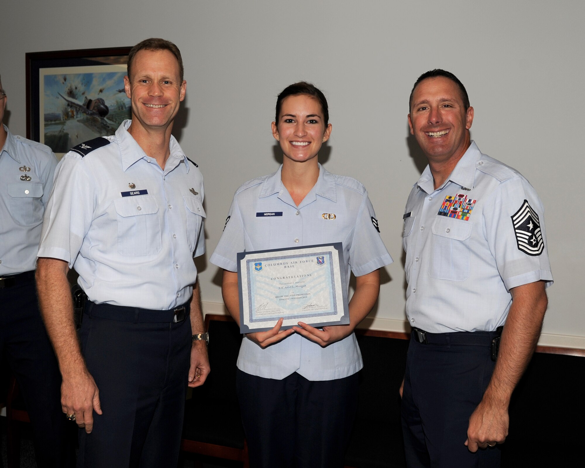 Airman 1st Class Ariel Morgan, 14th Operations Support Squadron is awarded senior airman Below-The-Zone by Col. Jim Sears, 14th Flying Training Wing Commander and Chief Master Sgt. Vance Kondon, 14th Flying Training Wing Command Chief. (U.S. Air Force/Melissa Doublin)