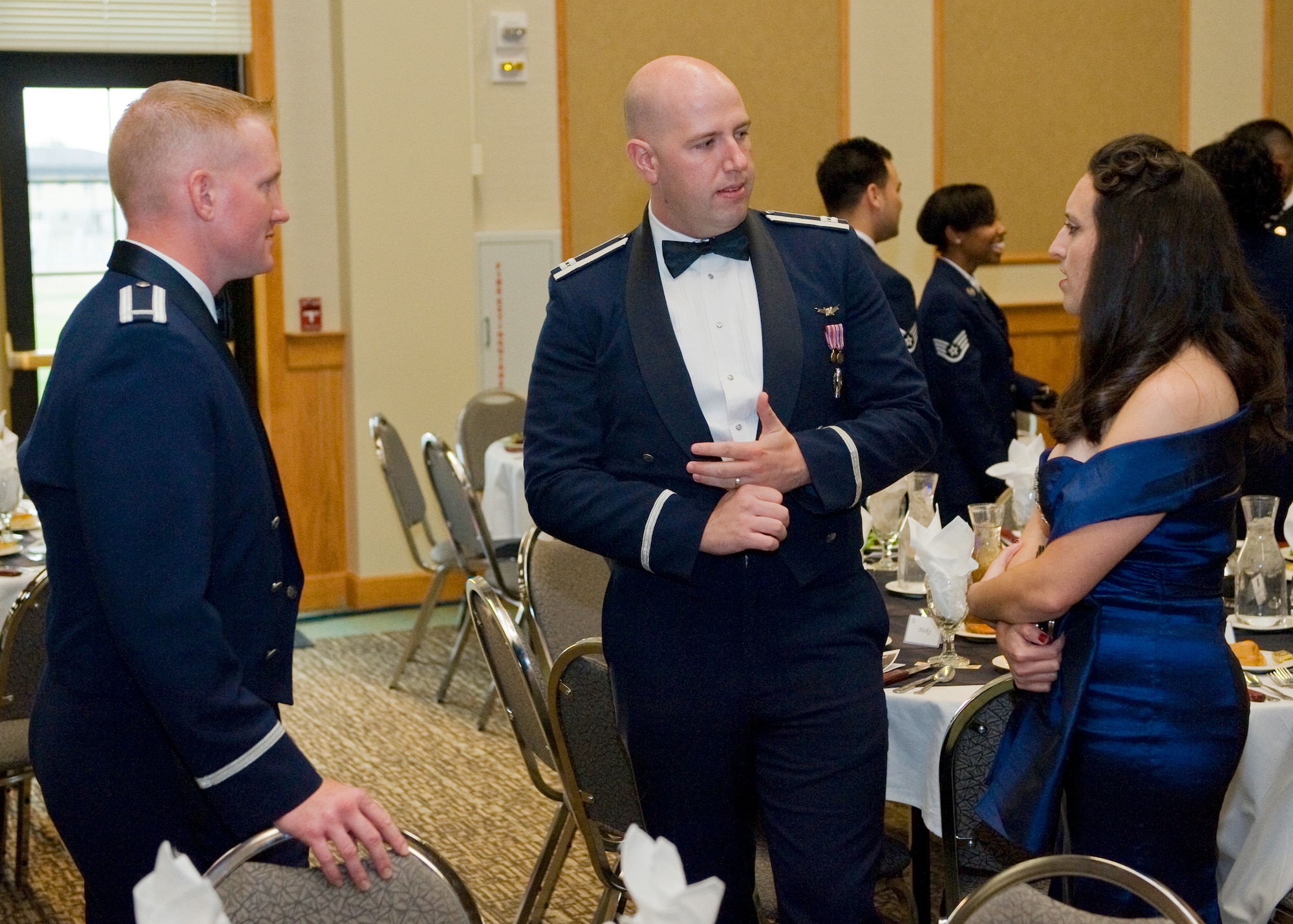1st Lt. Lee Feldhausen, 341st Operations Support Squadron ICBM instructor combat crew commander and master of ceremonies, far left, Capt. Matthew Berry, 341st Operations Support Squadron ICBM codes controller, and Allison Berry visit during the social hour of the Air Force Ball. Members at the event were served a dinner and given a short history of the Air Force in celebration of the service’s birthday. (U.S. Air Force photo/Beau Wade)