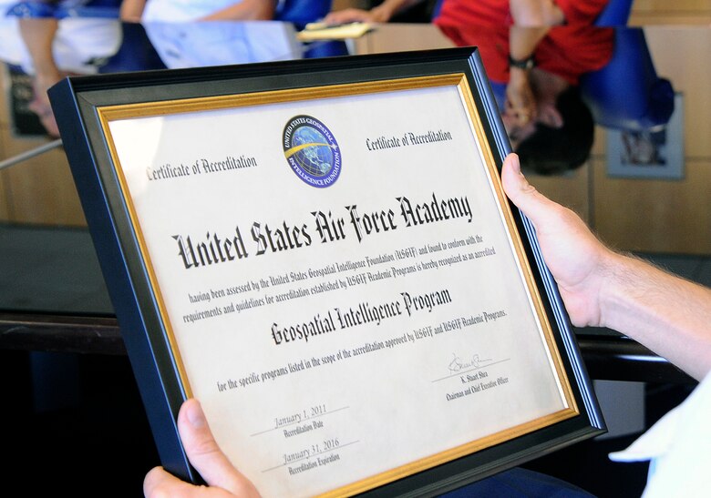 The Air Force Academy's Economics and Geosciences Department receives a geospatial intelligence accreditation from Keith Masback, president of the U.S. Geospatial Intelligence Agency, during a ceremony at the Air Force Academy Sept. 10, 2012. The certificate allows the Academy to offer geospatial intelligence certificates to its graduates. (U.S. Air Force photo/Mike Kaplan)