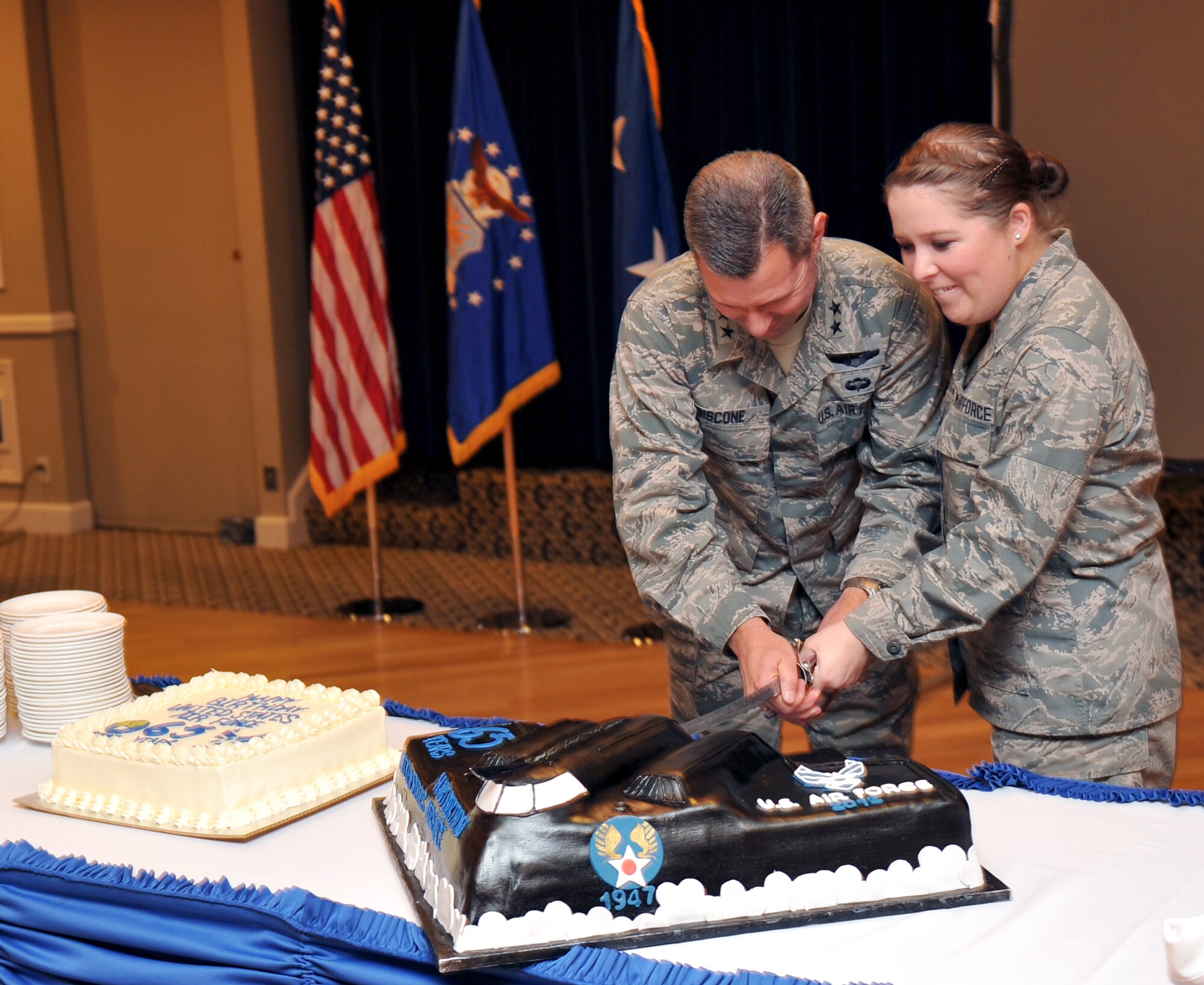 U.S. Air Force Maj. Gen. Gregory A. Biscone, Director of Global Operations, U. S. Strategic Command, Offutt Air Force Base, Neb., and U.S. Air Force Airman Katlynn Edlin, 55th Force Support Squadron, cut the cake for the 65th Air Force birthday at the Patriot Club Sept. 18. The cake-cutters were selected to represent the branch as the most senior and most junior Air Force members at the event. (U.S. Air Force photo by Jeff W. Gates/Released)