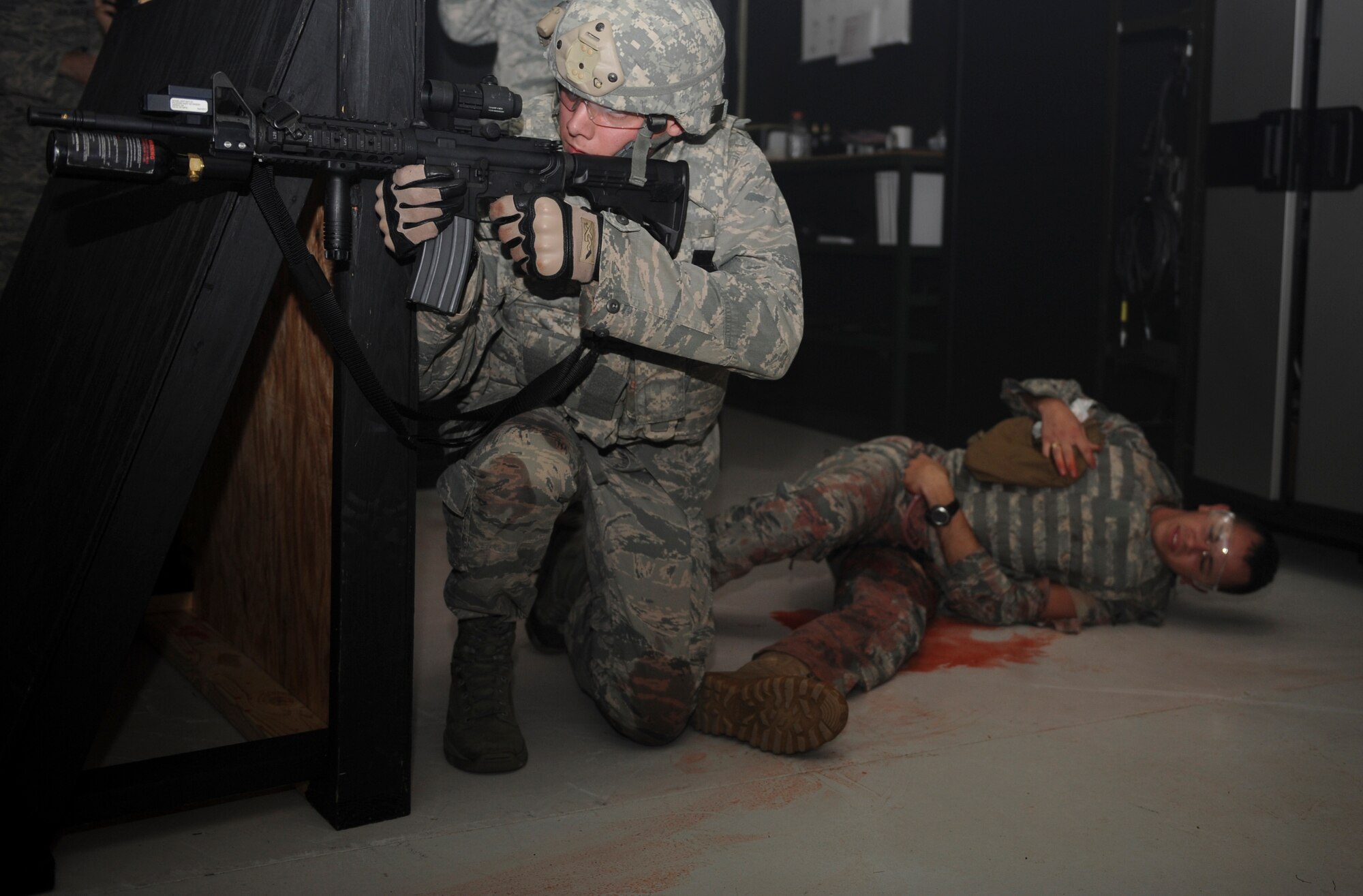 An Airman from the 822nd Base Defense Squadron returns fire at opposing forces before evacuating casualties during self-aid and buddy care training with principles of tactical combat casualty care at Moody Air Force Base, Ga., Sept. 5, 2012. The goal of the course is to better prepare battlefield Airmen for combat situations downrange. (U.S. Air Force photo by Senior Airman Douglas Ellis/Released)
