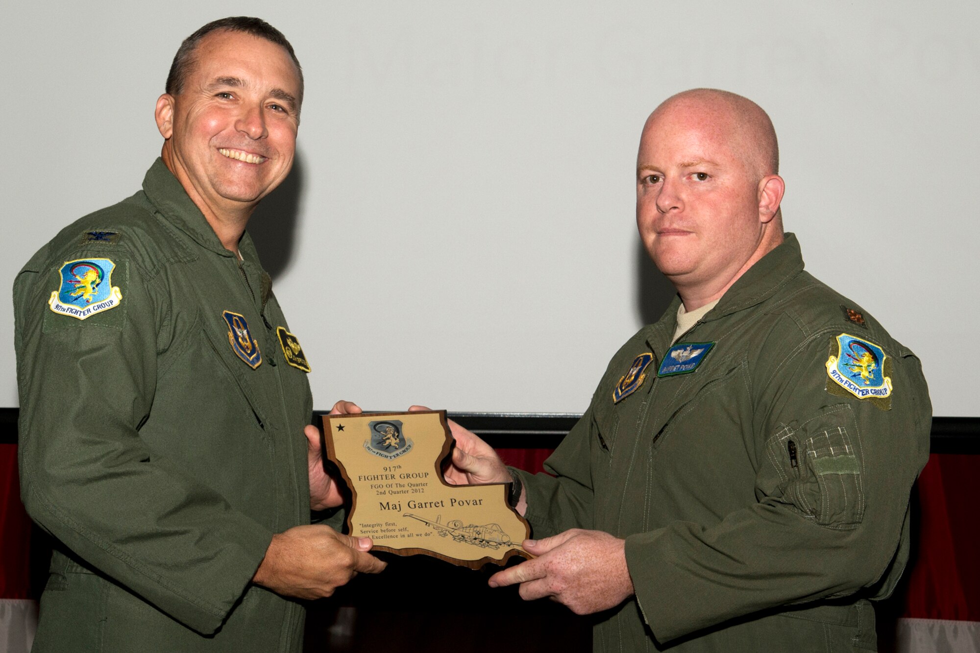 U.S. Air Force Col. John Breazeale, 917th Fighter Group commander, presents an award to Maj. Garret Povar during a Commander's Call ceremony, Sept. 9, 2012, Barksdale Air Force Base, La. Povar was selected as Field Grade Officer of the Quarter, 2nd Quarter 2012. (U.S. Air Force photo by Master Sgt. Greg Steele/Released)
