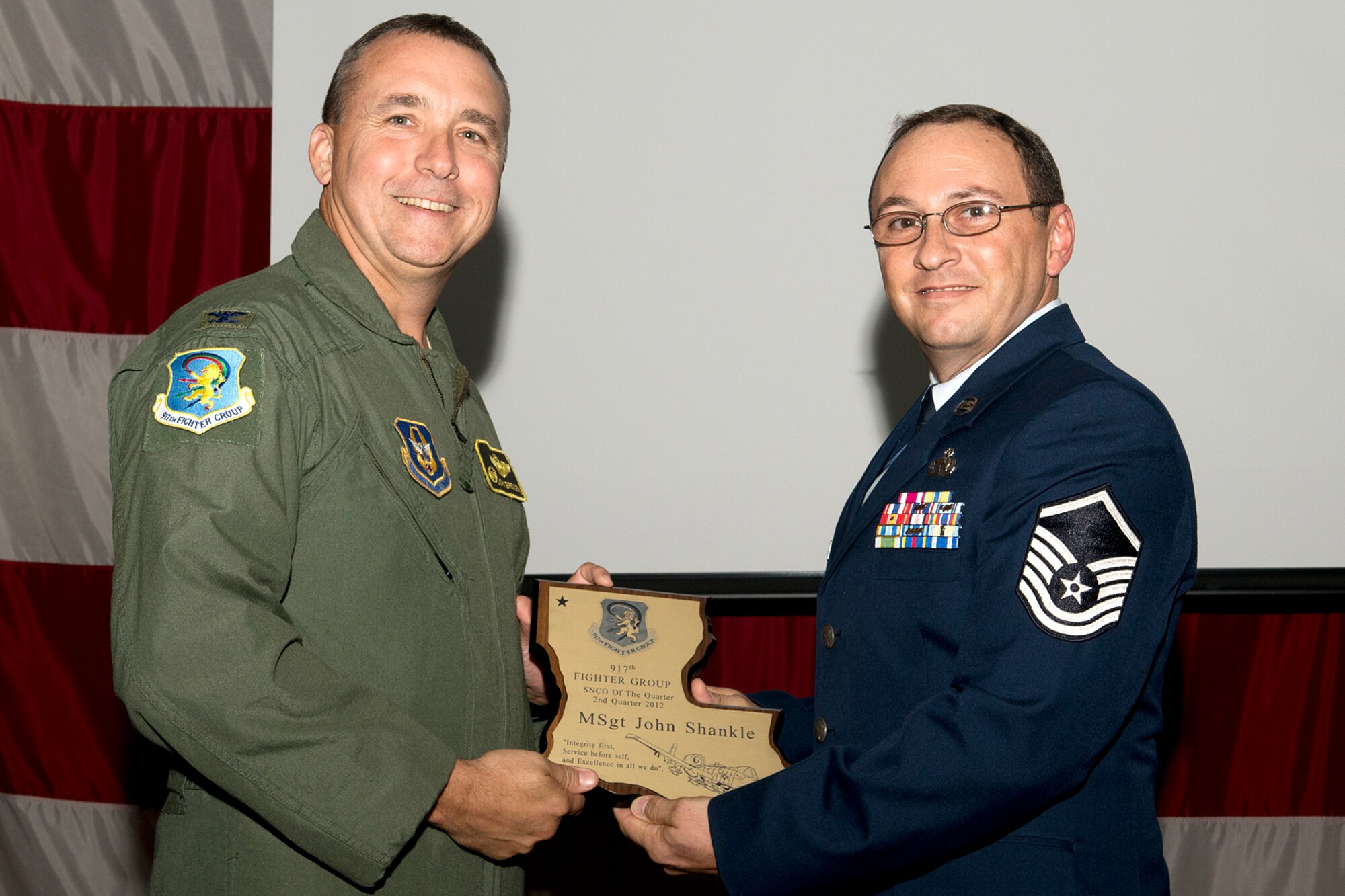 U.S. Air Force Col. John Breazeale, 917th Fighter Group commander, presents an award to Master Sgt. John Shankle during a Commander's Call ceremony, Sept. 9, 2012, Barksdale Air Force Base, La. Shankle was selected as the Senior Noncommissioned Officer of the Quarter, 2nd Quarter 2012. (U.S. Air Force photo by Master Sgt. Greg Steele/Released)