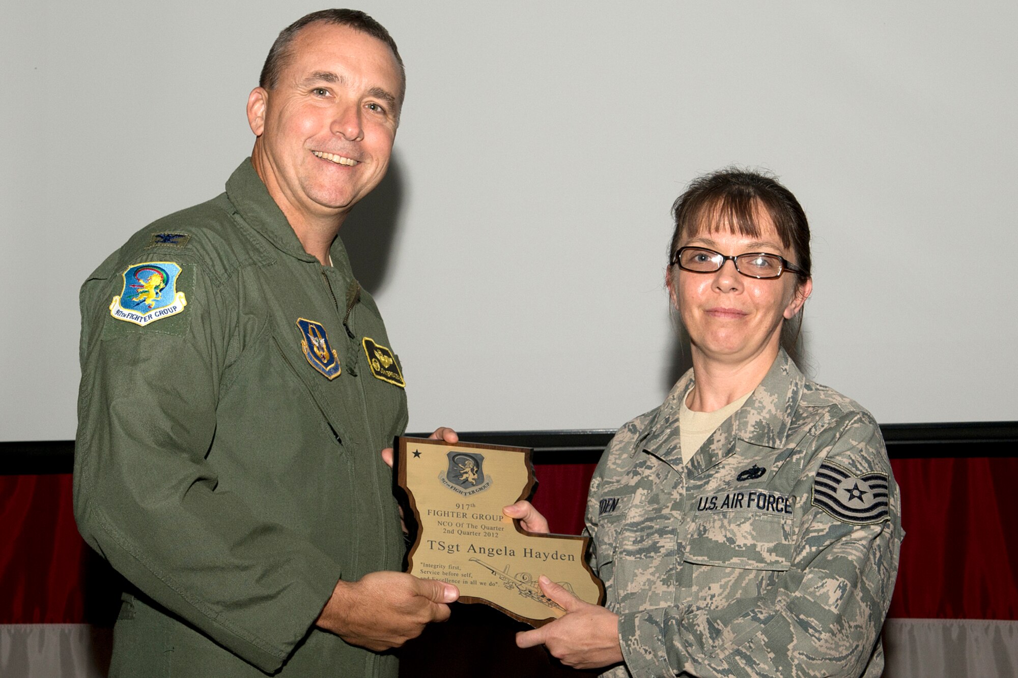 U.S. Air Force Col. John Breazeale, 917th Fighter Group commander, presents an award to Tech. Sgt. Angela Hayden during a Commander's Call ceremony, Sept. 9, 2012, Barksdale Air Force Base, La. Hayden was selected as the Noncommissioned Officer of the Quarter, 2nd Quarter 2012. (U.S. Air Force photo by Master Sgt. Greg Steele/Released)
