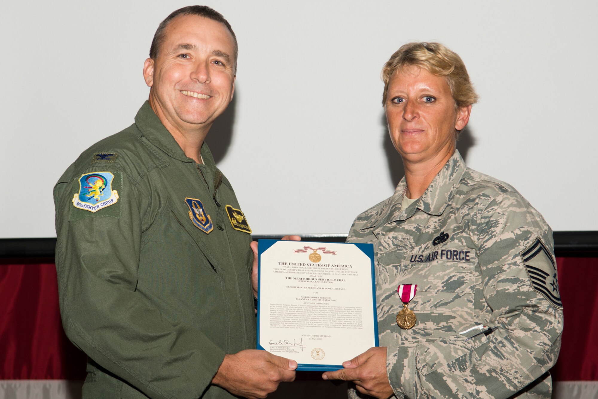 U.S. Air Force Col. John Breazeale, 917th Fighter Group commander, presents the Meritorious Service Medal to Senior Master Sgt. Bonnie Reeves during a Commander's Call ceremony, Sept. 9, 2012, Barksdale Air Force Base, La. Reeves distinguished herself during a deployment to Peterson Air Force Base, Colo. (U.S. Air Force photo by Master Sgt. Greg Steele/Released)