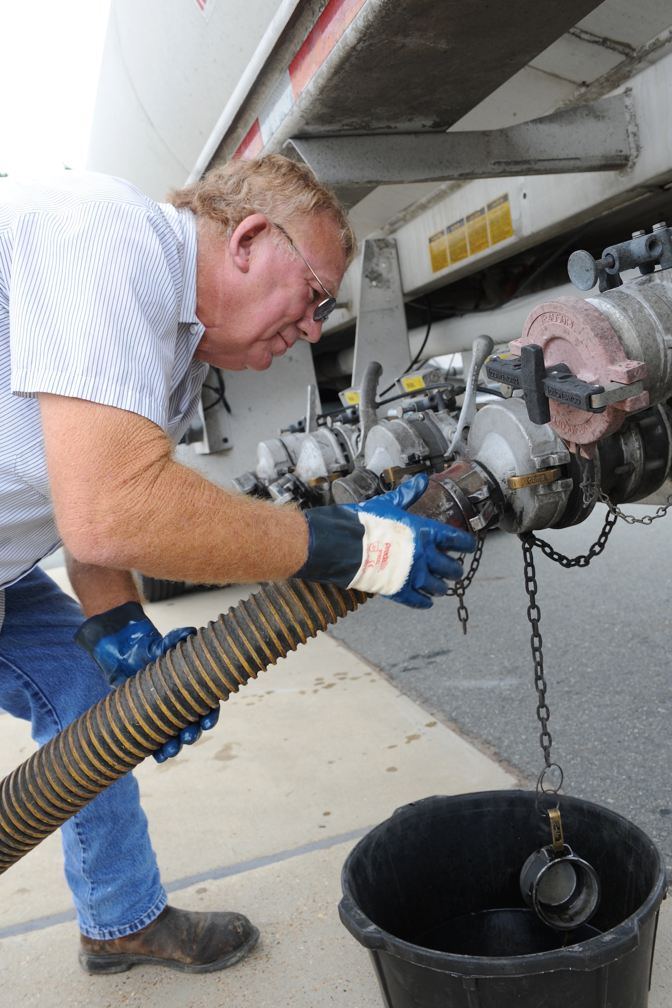 Bill McCarty, Delta Fuel, carefully connects a hose to a fuel tank truck on Barksdale Air Force Base, La., Sept. 18. The truck has four compartments that store fuel. When one compartment is empty, the hose connected to it is removed and connected to a new one. (U.S. Air Force photo/Airman 1st Class Benjamin Gonsier)(RELEASED)
