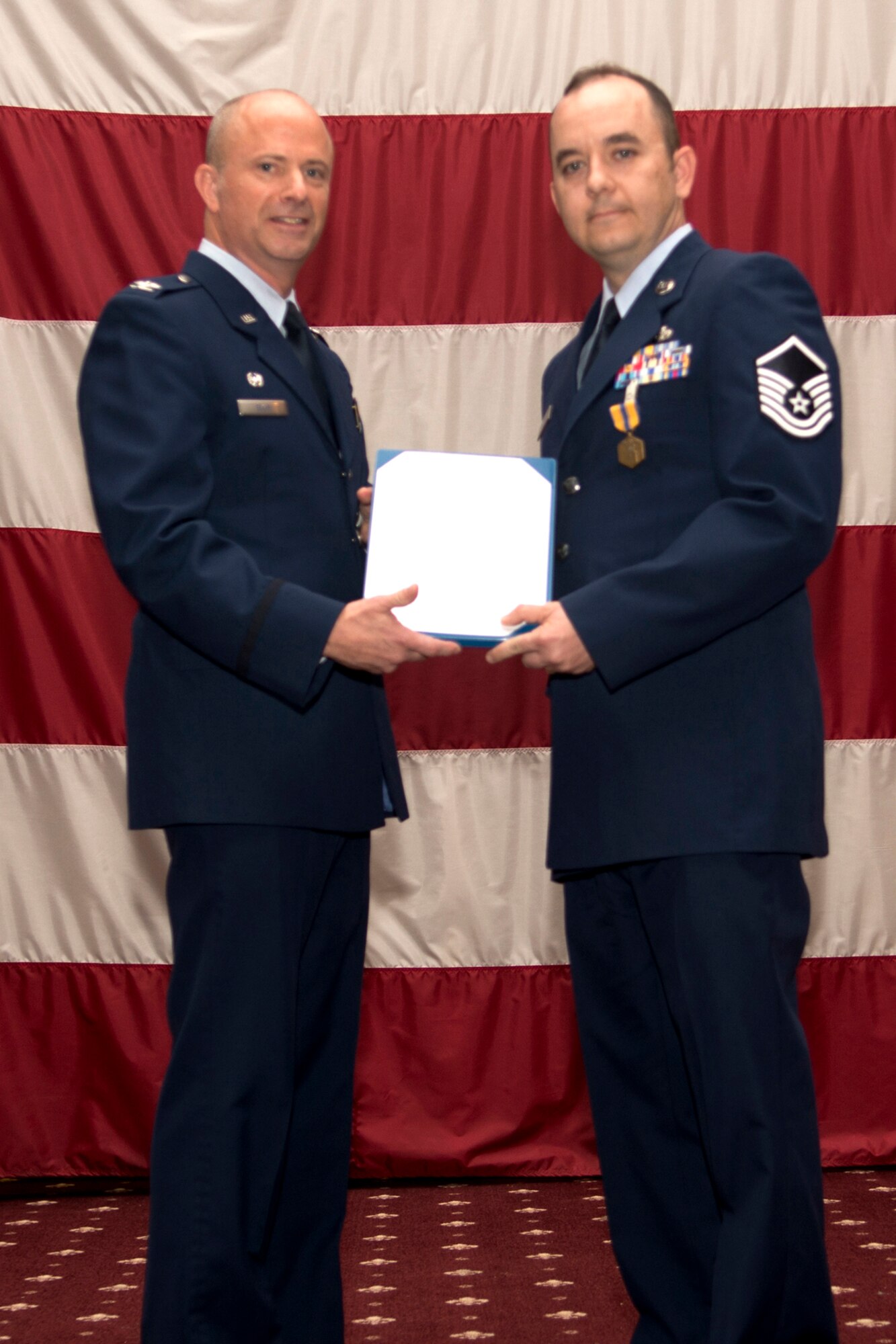 U.S. Air Force Col. Jonathan Ellis, 307th Bomb Wing commander, presents the Air Force Commendation Medal to Master Sgt. Jason Colvin during a Commander's Call, Sept. 9, 2012, Barksdale Air Force Base, La. Colvin distinguished himself by outstanding achievement while assigned to the 506th Expeditionary Civil Engineer Squadron, Kirkuk Regional Air Base, Iraq. (U.S. Air Force photo by Staff Sgt. Ted Daigle/Released)
