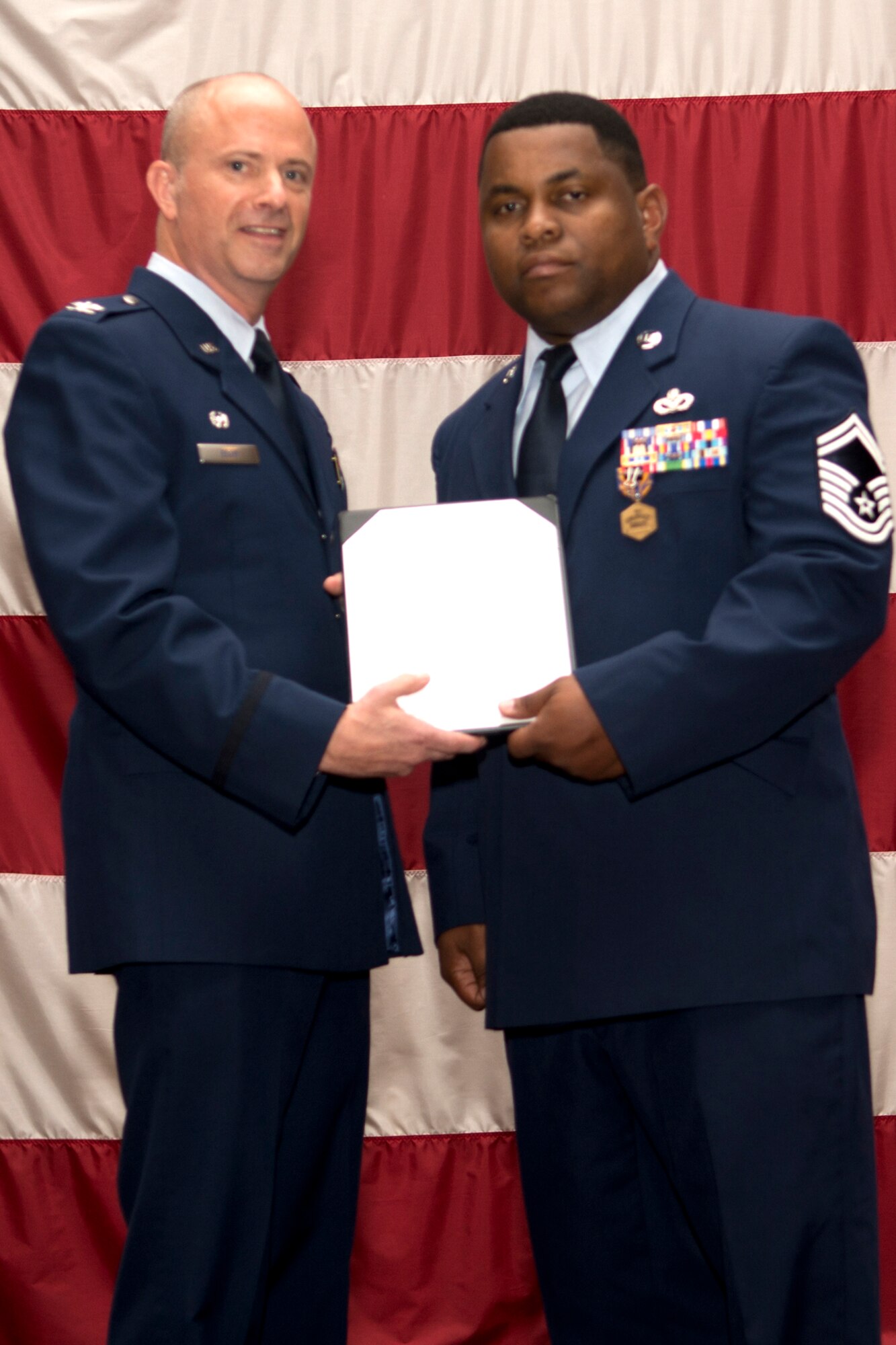 U.S. Air Force Col. Jonathan Ellis, 307th Bomb Wing commander, presents the Air Force Commendation Medal to Senior Master Sgt. Charles Harkless during a Commander's Call, Sept. 9, 2012, Barksdale Air Force Base, La. Harkless distinguished himself by outstanding achievement while assigned to the 506th Expeditionary Civil Engineer Squadron, Kirkuk Regional Air Base, Iraq. (U.S. Air Force photo by Staff Sgt. Ted Daigle/Released)