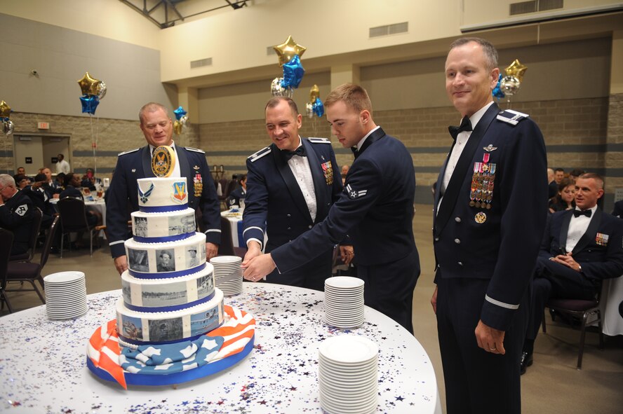 U.S. Air Force Chaplain (Lt. Col.) Stephen Voyt, 23d Wing chaplain, and Airman 1st Class Brandon Sabin, 23d Wing Public Affairs broadcaster, perform the traditional cake cutting ceremony during the Air Force Ball in Valdosta, Ga., Sept. 14, 2012. It is a tradition that the oldest person and youngest person assigned to base cut the first slice. (U.S Air Force photo by Airman 1st Class Olivia Dominique/Released)