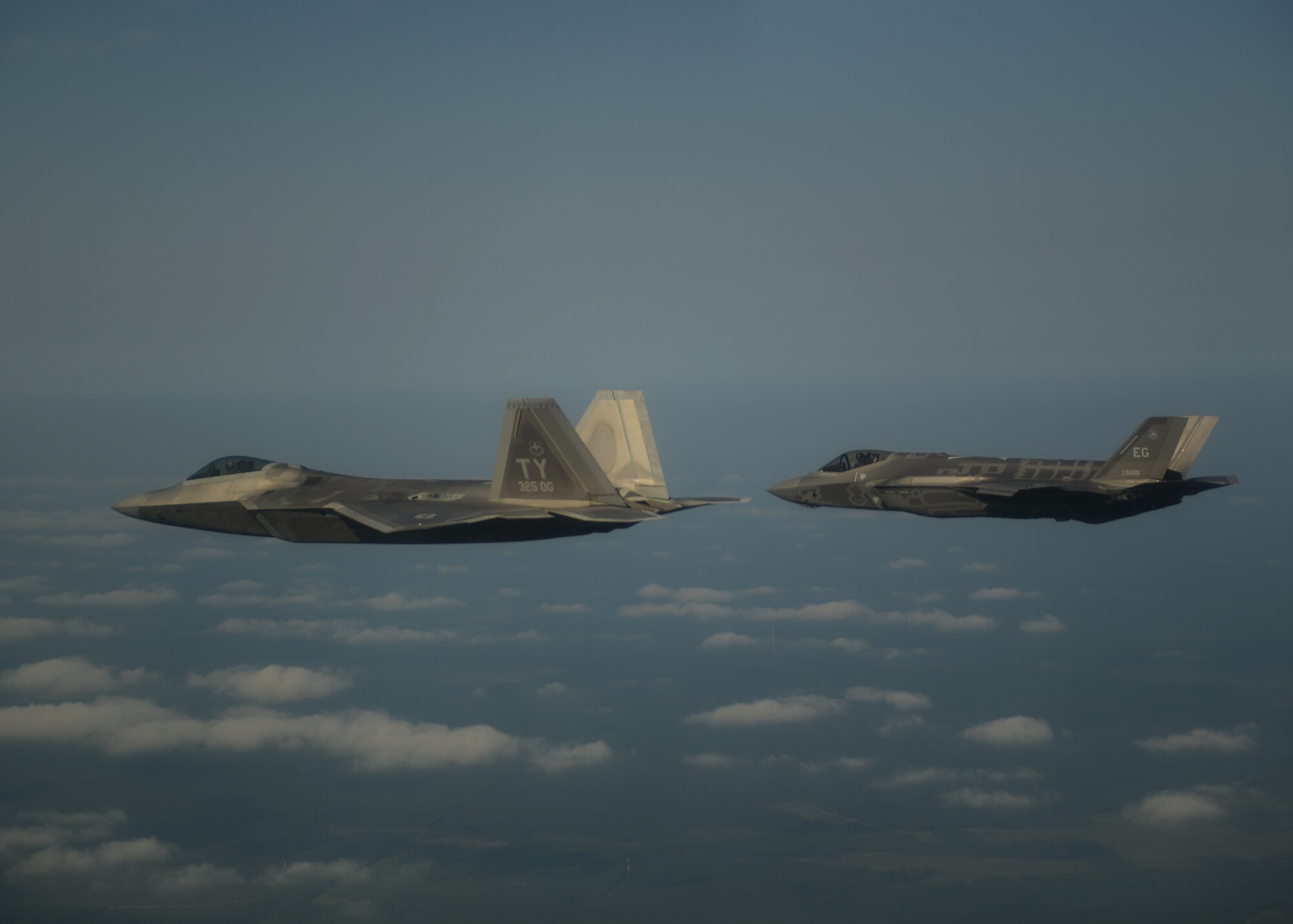 An F-22A Raptor from the 325th Fighter Wing at Tyndall Air Force Base, Fla., and an F-35A Lightning II joint strike fighter from the 33rd Fighter Wing at Eglin Air Force Base, Fla., soar over the Eglin range Sept. 19.  This was the first time the two fifth generation fighters have flown together for the Air Force.  (U.S. Air Force photo/Master Sgt. Jeremy T. Lock)