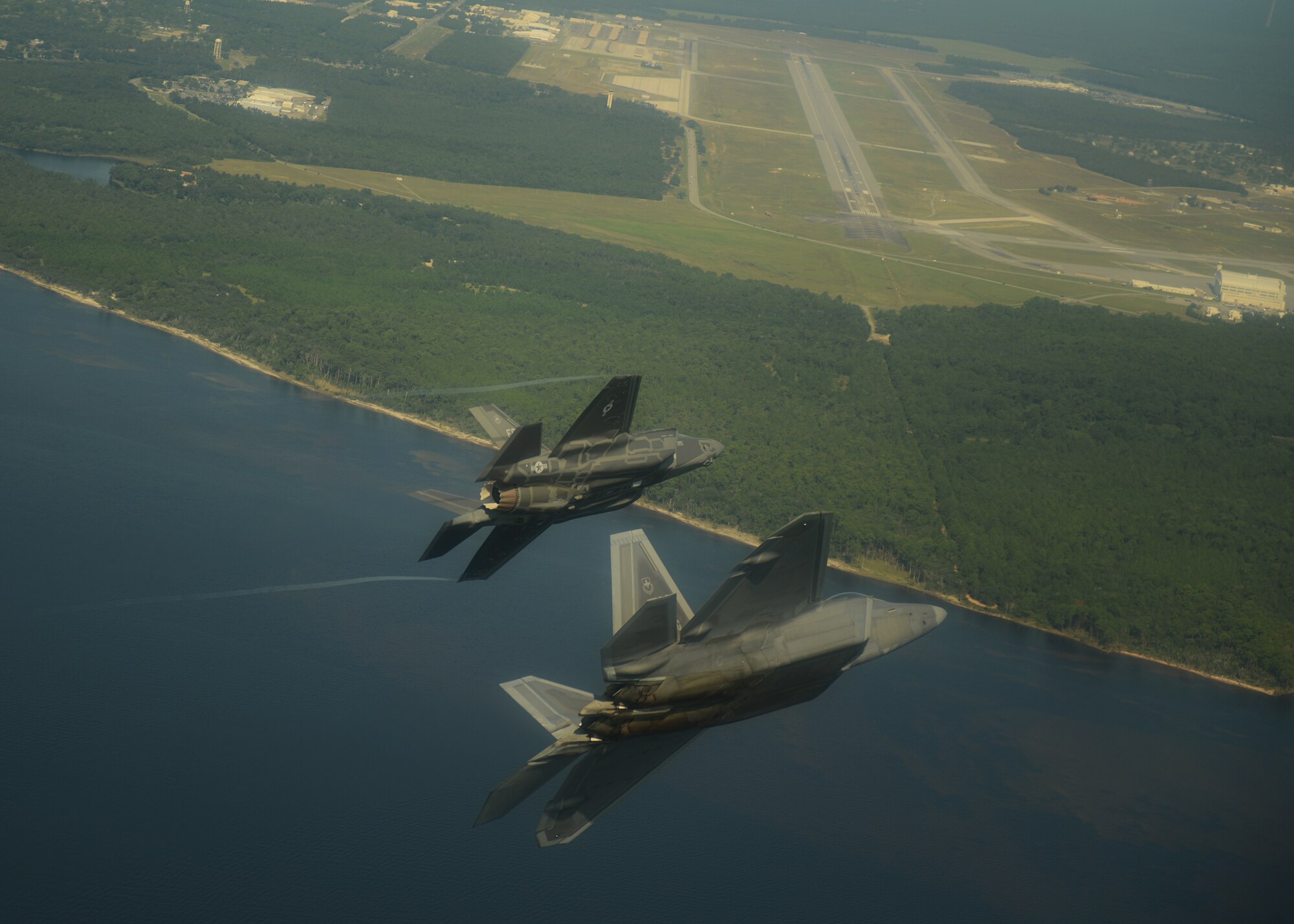 An F-35A Lightning II joint strike fighter from the 33rd Fighter Wing, and an F-22A Raptor from the 325th Fighter Wing at Tyndall Air Force Base, Fla., turn toward the Eglin Air Force Base runway Sept. 19.  This was the first time the two fifth generation fighters have flown together for the Air Force. (U.S. Air Force photo/Master Sgt. Jeremy T. Lock)