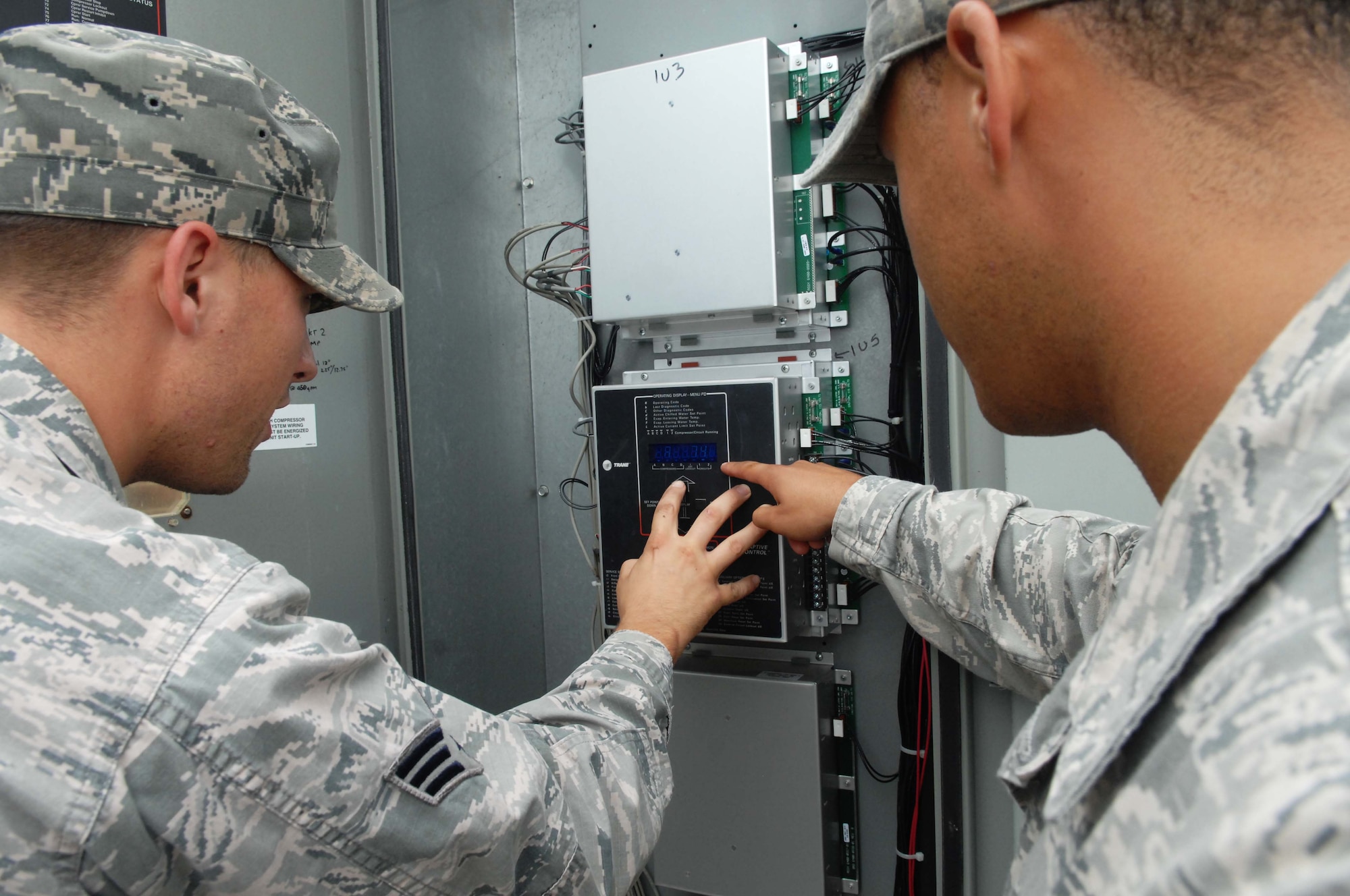 Staff Sgt. Aaron Washington (right) and Senior Airman Kevin Gillaspie, 633rd Civil Engineer Squadron heating, ventilation and air conditioning technicians, make the appropriate adjustments to an HVAC system after running tests on the system, Sept. 18, 2012, at Langley Air Force Base, Va. With tasks like these, civil engineers take the data collected and conduct a “repair versus replace” analysis to determine the best way to handle the system. (U.S. Air Force photo by Airman 1st Class Austin C. Harvill/Released)