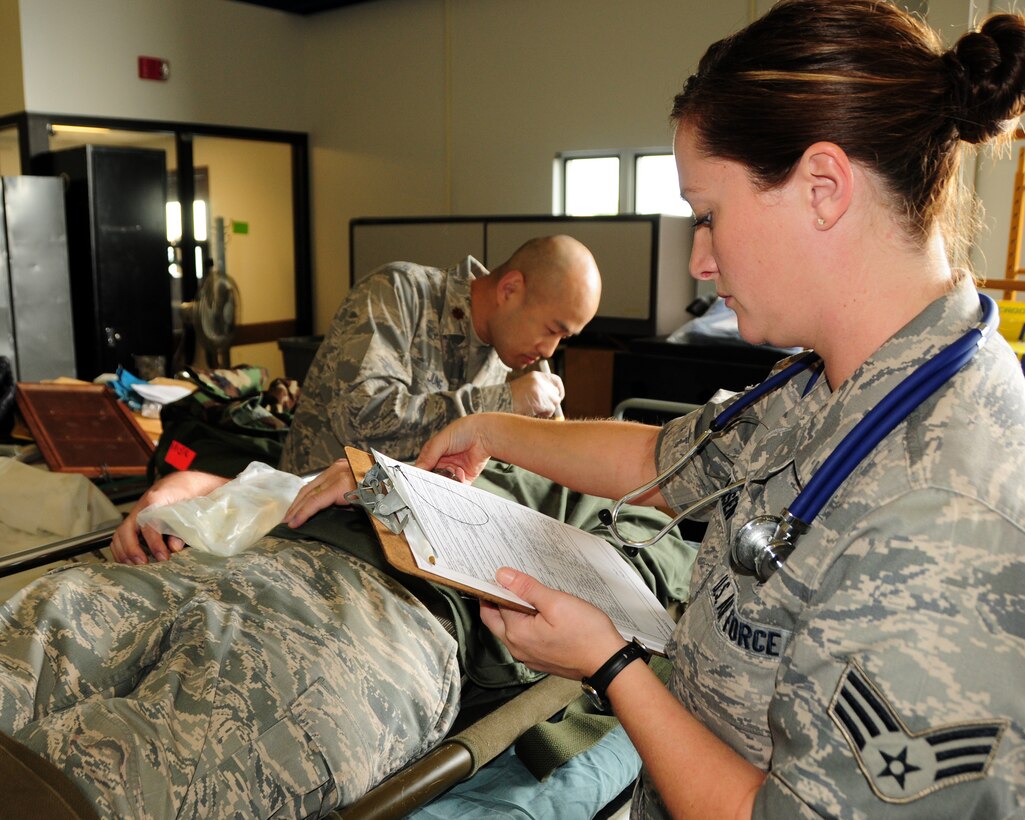 Senior Airman Angela Hansen 914th Aero Patient Staging Squadron, Medical Technician, checks vital signs of a patient while Maj. Hoon Jung 914th Aero Patient Staging Squadron, Physician, examines and assesses the patient for neurological trauma during a recent mass causality exercise which involved a multiple vehicle collision at the Niagara Falls Air Reserve Station, NY on September 9, 2012. The exercise was conducted to test the medical readiness and skills of the unit during an emergency. This exercise is an annual requirement for the ASTS. (US Air Force photo by Peter Borys)