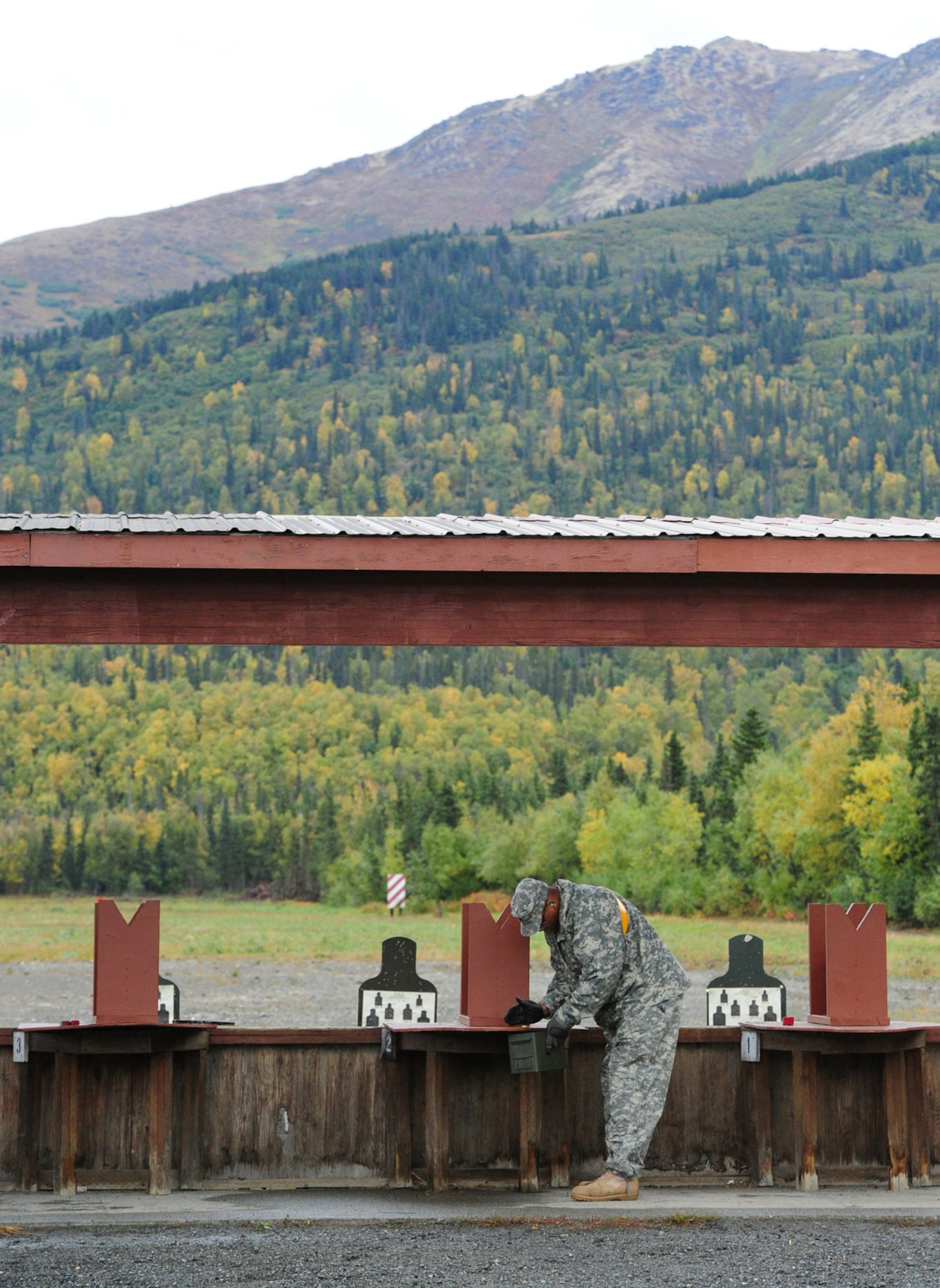 Army Staff Sgt. Artis Smith, 95th Chemical Company, of Fayetteville, N.C., polices spent brass on the firing line at a pistol range Sept. 14. (U.S. Air Force photo/Justin Connaher)