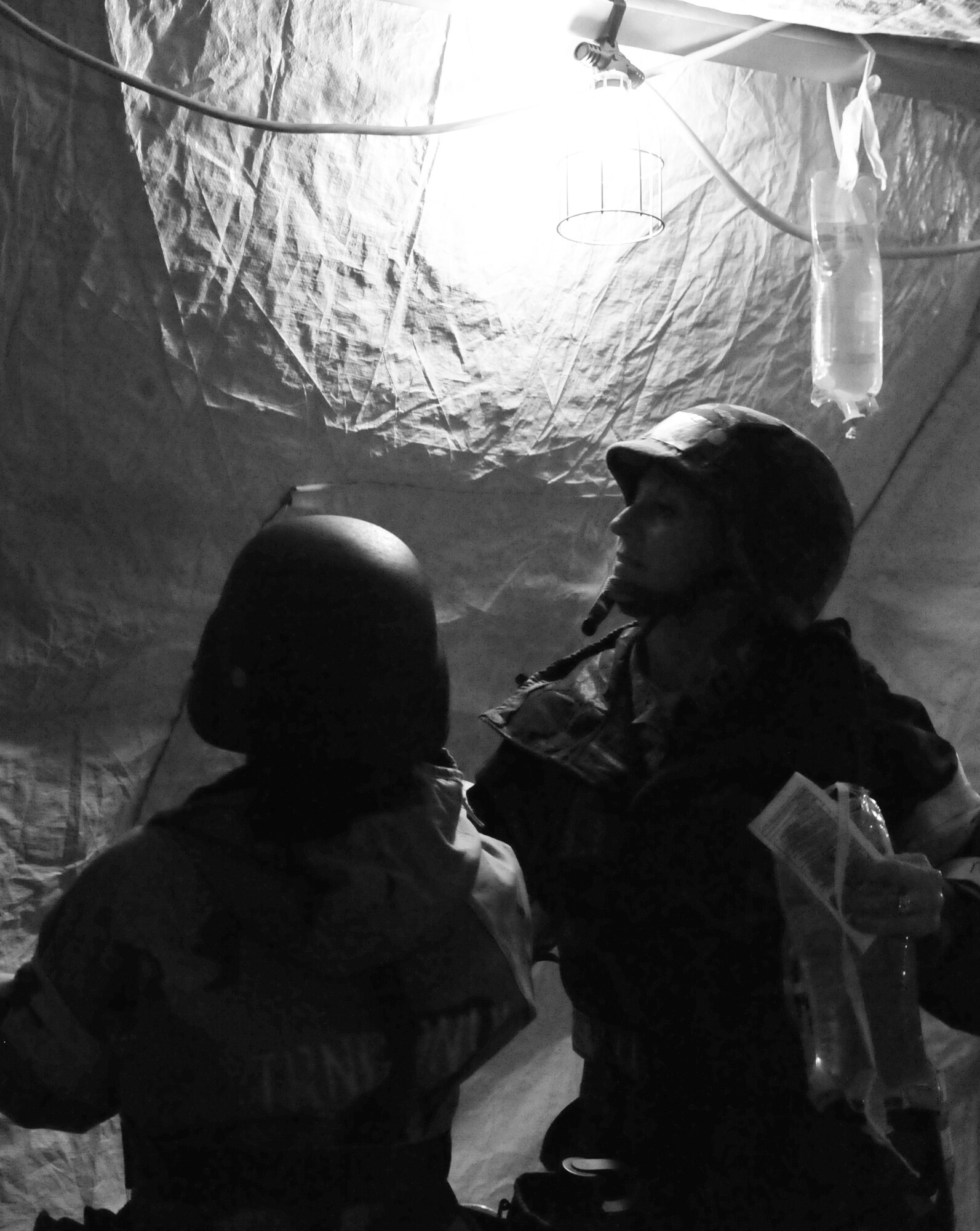 U.S. Air Force Airmen from the 4th Medical Operations Squadron prepare an intravenous drip bag to deliver fluids and medication to a moulage patient under minimal-lighting for simulated emergency medical treatment during Operational Readiness Exercise Coronet Warrior 12-04 at Base X on Seymour Johnson Air Force Base, N.C., Sept. 19, 2012.  Medical technicians assigned to the 4th MDOS provide critical life-saving treatment to wounded personnel in a simulated deployed location. (U.S. Air Force photo/2nd Lt. Keavy Rake)