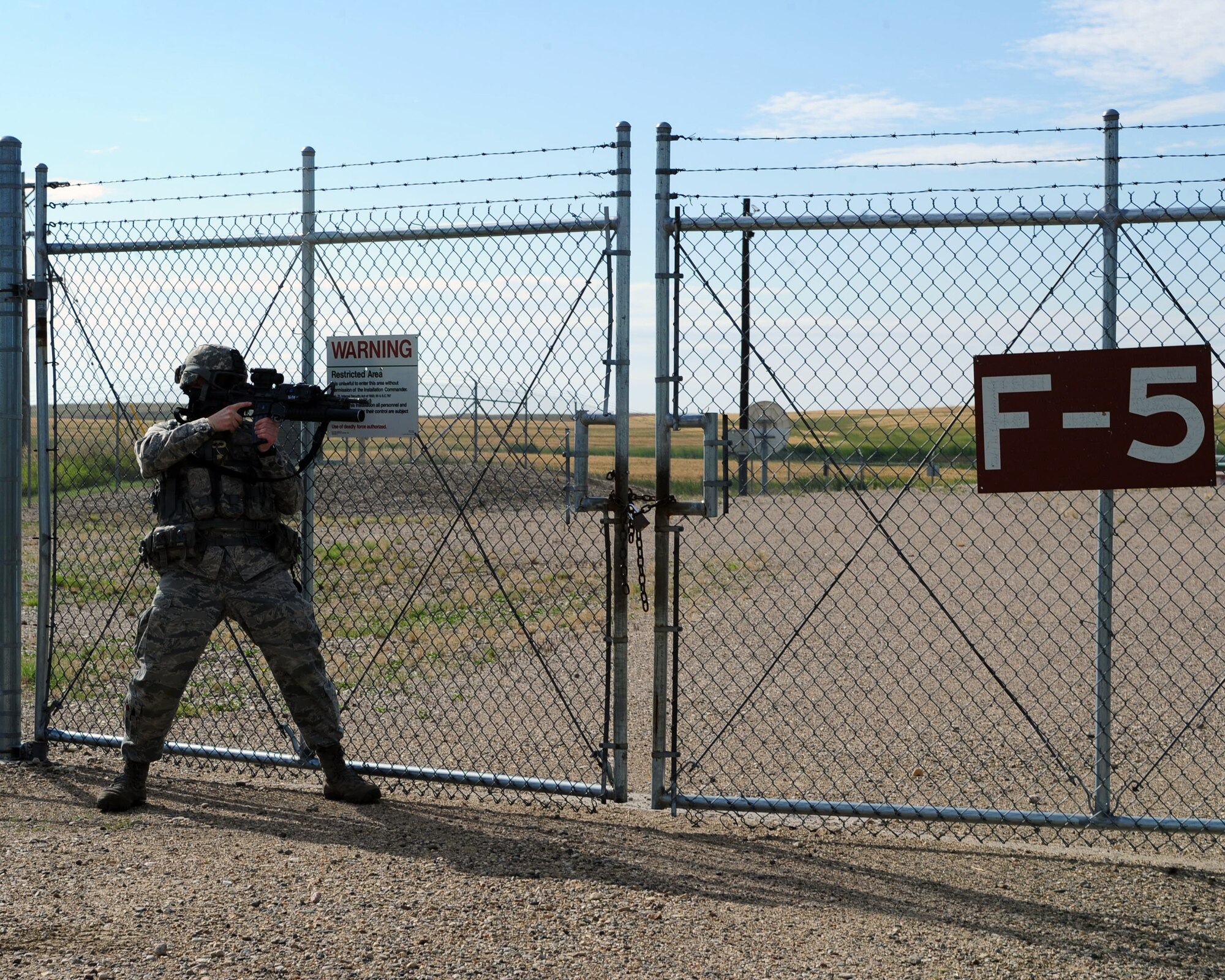 MINOT MISSILE COMPLEX, N.D. -- Airman 1st Class Antonio Varisco, 91st Missile Security Forces Squadron response force leader, stands ready at the perimeter of a launch facility during a security situation training scenario. Members of the 91st MSFS provide constant security to national assets located in the missile complex. (U.S. Air Force photo/Senior Airman Michael J. Veloz)