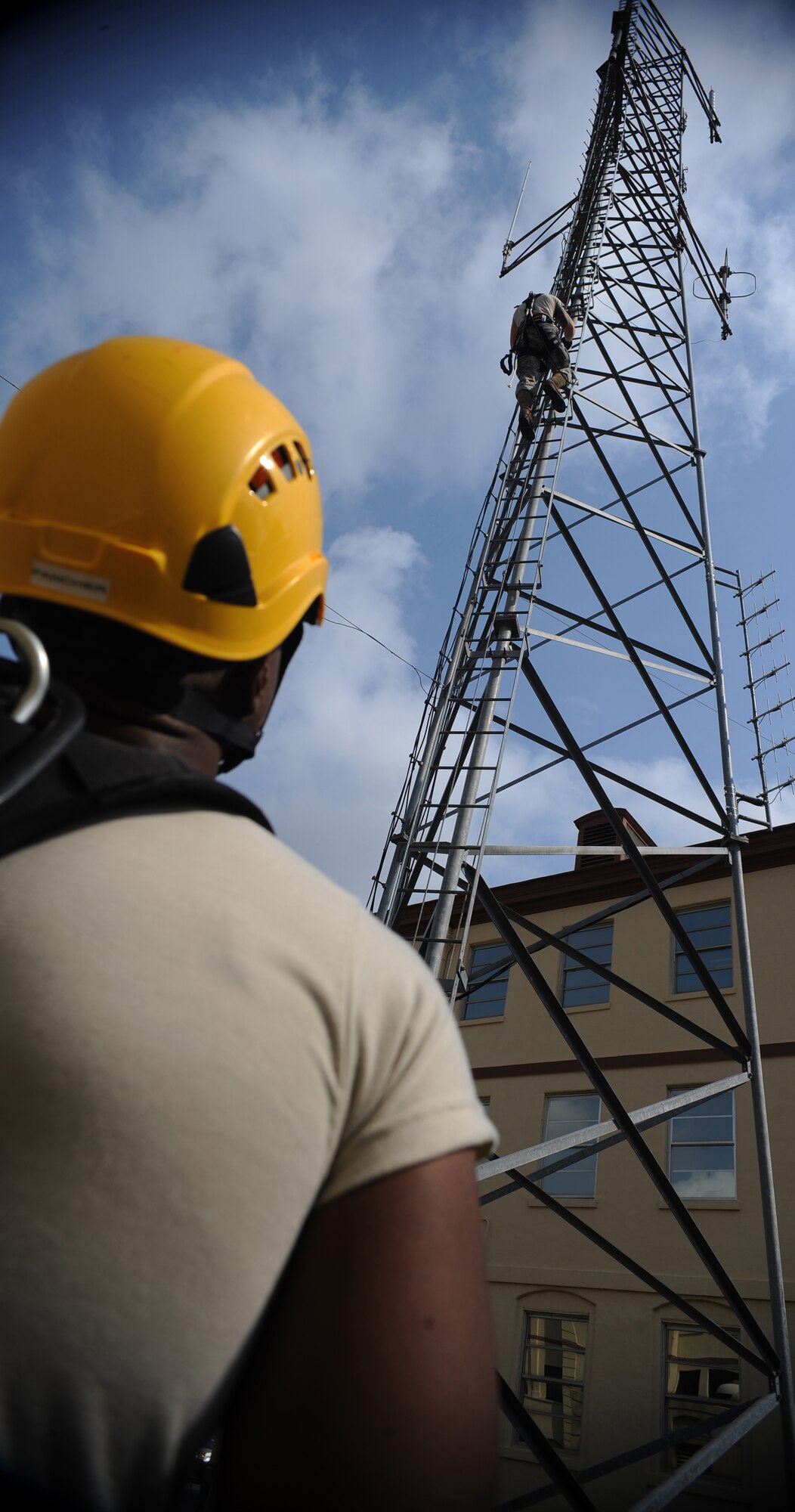 Airman 1st Class Major Powell watches as Airman 1st Class Creston Jenkins, both members of the 2nd Communications Squadron, climbs down from an antenna tower on Barksdale Air Force Base, La., Sept. 18. Powell acted as the safety observer during Jenkins' descent. Safety observers alert climbers of any dangers or hazards, assist climbers with tools and provide medical assistance in the event of a mishap. (U.S. Air Force photo/Senior Airman Micaiah Anthony)(RELEASED)