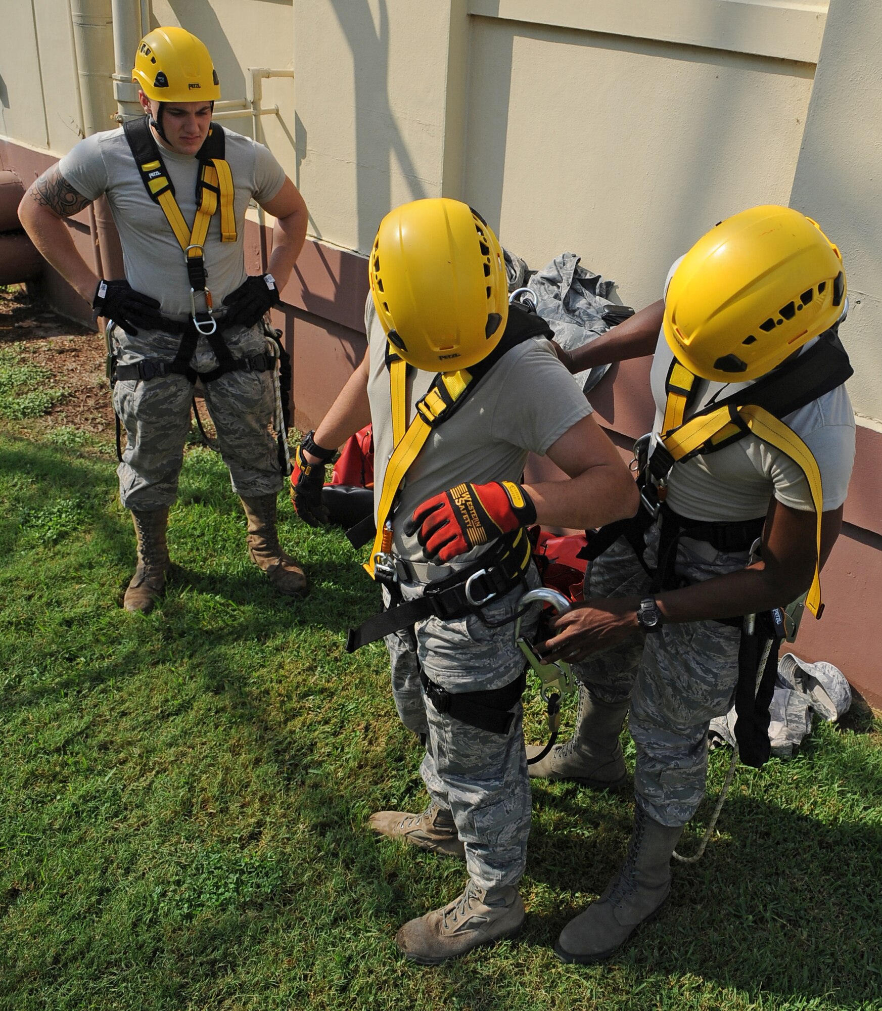 Cable Dawgs from the 2nd Communications Squadron check each other's safety harnesses on Barksdale Air Force Base, La., Sept. 18. The Airmen donned the harnesses so they could climb a tower to inspect antennas. In addition to safety harnesses, Cable Dawgs wear helmets, gloves and special boots to assist them in climbing. (U.S. Air Force photo/Senior Airman Micaiah Anthony)(RELEASED)