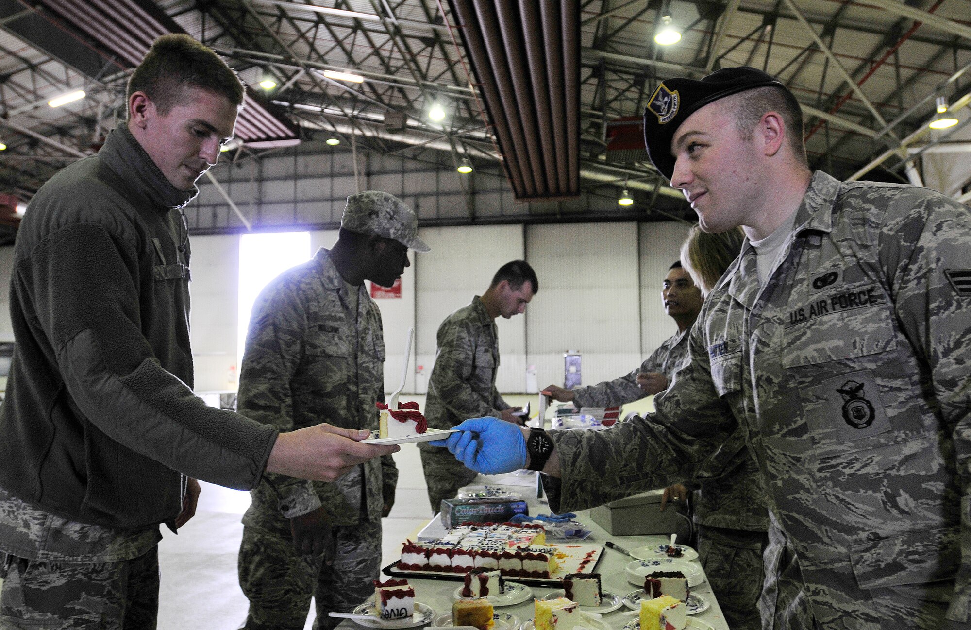 ROYAL AIR FORCE LAKENHEATH, England - Airman 1st Class Edward Hatten, 48th Security Forces Squadron Pass and Registration clerk (right), hands a slice of cake to A1C Chasen Milner, 48th Communications Squadron airfield systems journeyman, at the Combined Federal Campaign Kick-off Sept. 19, 2012. The event provided pizza, cake and the opportunity for Airmen and other federal employees to donate to the CFC. To learn more about the CFC, contact your unit representative or visit www.cfcoverseas.org. (U.S. Air Force photo by Senior Airman Tiffany M. Grigg) 