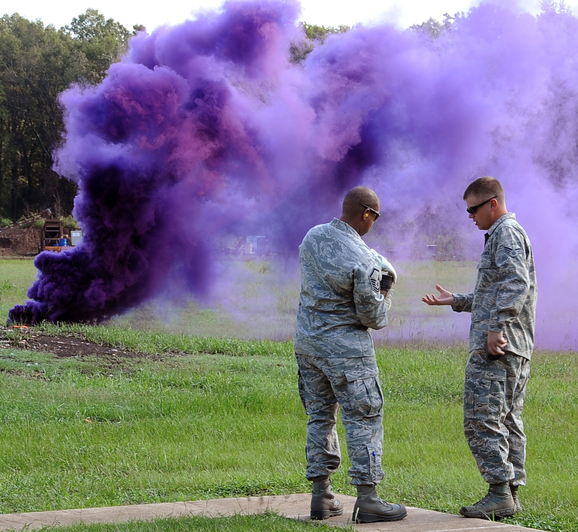 Senior Airman Timothy Habedank (right), 2nd Civil Engineer Squadron Explosive Ordnance Disposal technician, shows Master Sgt. Kevin Chambliss, 2nd Communications Squadron, how to properly hold an M-18 smoke grenade prior to throwing it at the EOD facility on Barksdale Air Force Base, La., Sept. 18. Habedank taught 11 Barksdale personnel how to use smoke grenades and ground burst simulators. (U.S. Air Force photo/Staff Sgt. Amber Ashcraft)(RELEASED)
