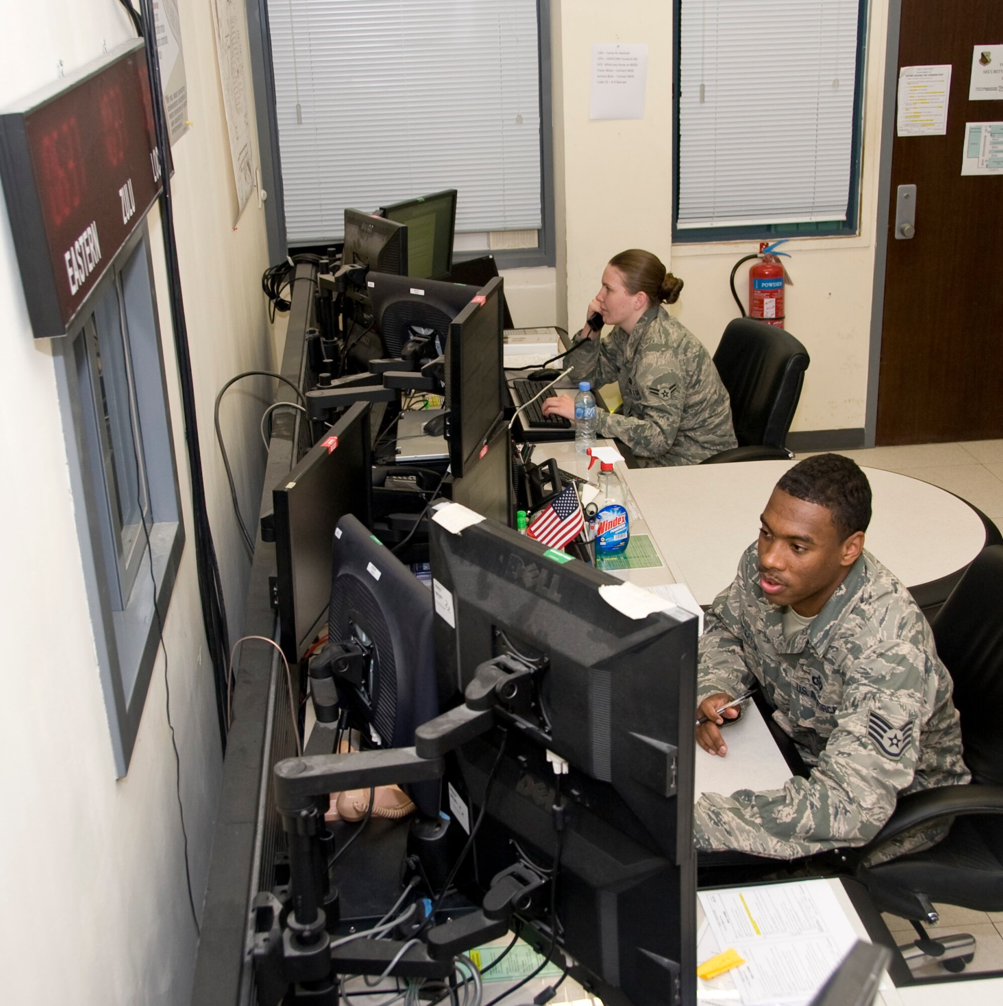 Staff Sgt. Dennis Patterson and Airman 1st Class Gabrielle Boone, 379th Air Expeditionary Wing Command Post controllers, flight follow every aircraft arriving or leaving the 379th AEW and coordinate plans with different agencies and organizations. The command post controllers are on duty 24 hours a day, seven days a week, 365 days a year to ensure base-wide safety and security. Patterson is deployed from Yakota Air Base, Japan, and Boone is deployed from Ramstein Air Base, Germany. (U.S. Air Force photo/Senior Airman Bryan Swink)