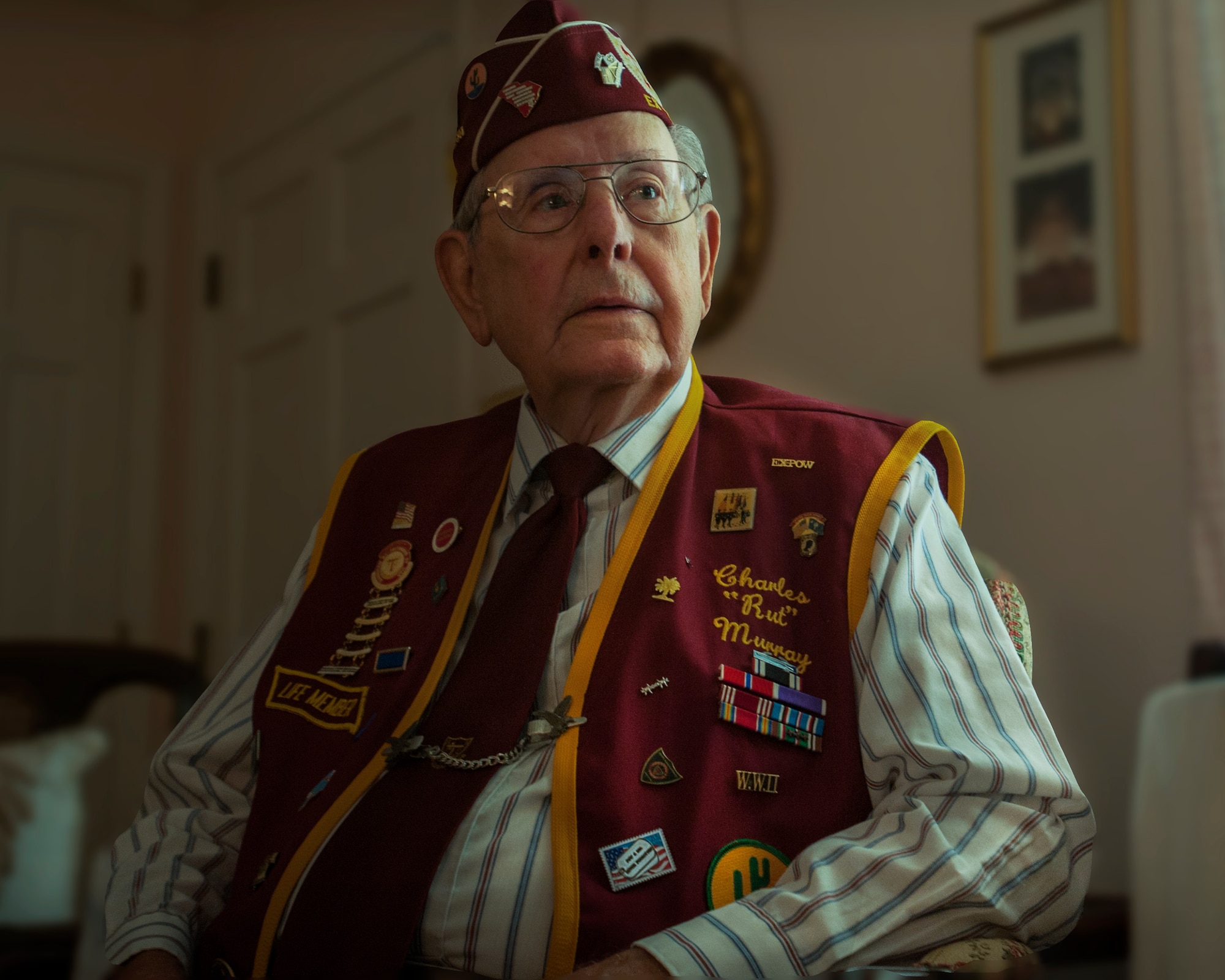 Rut Murray, 87-year-old World War II veteran and ex-Prisoner of War, explains the meaning behind the various patches and buttons on his Ex-American Prisoner of War – Lowcountry Chapter jacket at his home in Saint George, S.C. Murray was awarded the Bronze Star, Purple Heart and Prisoner of War Medals among many others during his military career. Murray spent 97 days as an American POW during World War II. He weighed only 97 pounds when he was liberated toward the end of the war. (U.S. Air Force Photo / Airman 1st Class Tom Brading)