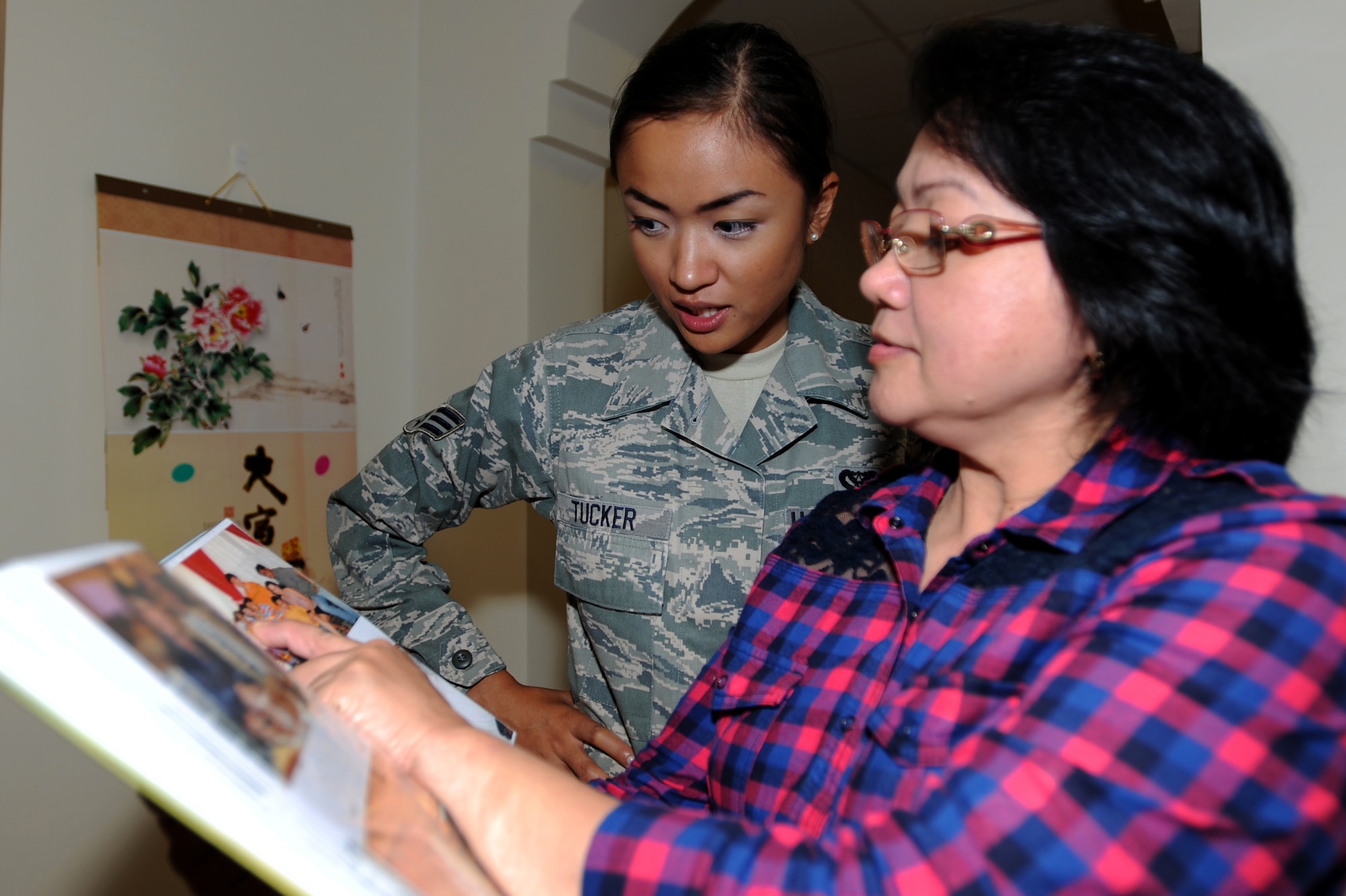 Lolly Pagdanganan shows Senior Airman Joyce Tucker pictures of her extended family at Southwest Asia, September 5, 2012. Tucker met her grandparents for the first time in 22 years while deployed. (U.S.  Air Force photo/Staff Sgt. Sheila deVera)