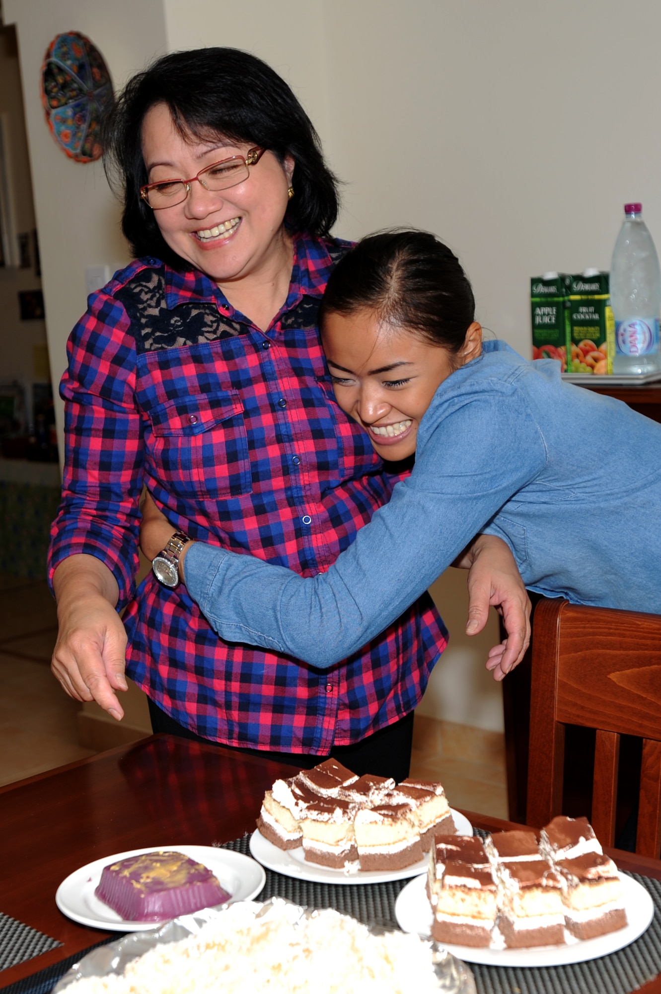 U.S. Air Force Senior Airman Joyce Tucker, 379th Expeditionary Civil Engineer Squadron construction site manager, hugs her grandmother, Lolly Pagdanganan, in Southwest Asia, September 5, 2012. Tucker recently met her grandparents for the first time in 22 years and is maximizing the time with them here while deployed. (U.S. Air Force photo/Staff Sgt. Sheila deVera)