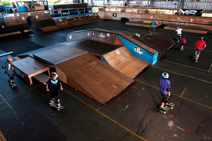 Young skaters take a warm-up lap around the street course at a skate lesson at the Hickam Skate Hangar, Joint Base Pearl Harbor-Hickam, Hawaii. The converted hangar is the only indoor wooden facility on all the Hawaiian Islands. It also boasts the only wooden keyhole bowls, or empty swimming pool shaped ramps, on Oahu. In addition, it has a 15,000 square foot street course, multiple mini ramps, 12-foot vertical ramp with a 14-foot tombstone connected to a saddle and three-quarter pipe. (U.S. Air Force photo/Staff Sgt. Mike Meares)