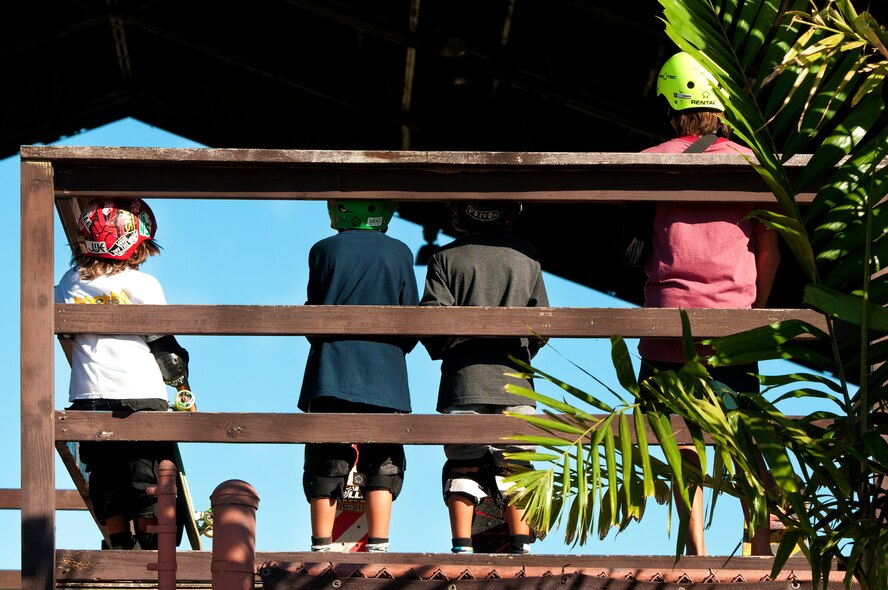 Young skaters wait their turn during lessons Sept. 3 at the Hickam Skate Hangar, Joint Base Pearl Harbor-Hickam, Hawaii. The converted hangar is the only indoor wooden facility on all the Hawaiian Islands. It also boasts the only wooden keyhole bowls, or empty swimming pool shaped ramps, on Oahu. In addition, it has a 15,000 square foot street course, multiple mini ramps, 12-foot vertical ramp with a 14-foot tombstone connected to a saddle and three-quarter pipe. (U.S. Air Force photo/Staff Sgt. Mike Meares)