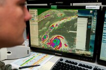 Airman 1st Class Derrick Smit, 17th Operational Weather Squadron weather technician, monitors two typhoons south of Japan Aug. 23, at the Pacific Air Forces Headquarters, Joint Base Pearl Harbor-Hickam, Hawaii. The 17th OWS recently completed a standardization and evaluation program for weather operations, or SEPWO, inspection where they scored 214 out of a possible 215 points, for a 99.53 percent passing score. Members of the squadron had to pay up on a shaving bet when they scored higher than 97 percent, including more than 75 years of continuous mustache growth. (U.S. Air Force photo/Staff Sgt. Mike Meares)