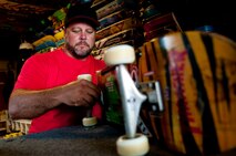 Mike Kays, operator of the Hickam Skate Hangar, repairs a skateboard inside the pro shop Aug. 22, Joint Base Pearl Harbor-Hickam, Hawaii. He has been working since the mid-1990’s to make the skate park a safe place for people to hangout and learn the art of skateboarding. The park is the only indoor wooden facility on all the Hawaiian Islands. (U.S. Air Force photo/Staff Sgt. Mike Meares)