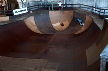 Kody Tamanaha, 8, of Mililani, Hawaii, skates inside a bowl while her brother, Ian, 10, waits his turns at the Hickam Skate Hangar Aug. 16 at Joint Base Pearl Harbor-Hickam, Hawaii. The converted hangar is the only indoor wooden facility on all the Hawaiian Islands. It also boasts the only wooden keyhole bowls, or empty swimming pool shaped ramps, on Oahu. In addition, it has a 15,000 square foot street course, multiple mini ramps, 12-foot vertical ramp with a 14-foot tombstone connected to a saddle and three-quarter pipe. (U.S. Air Force photo/Staff Sgt. Mike Meares)