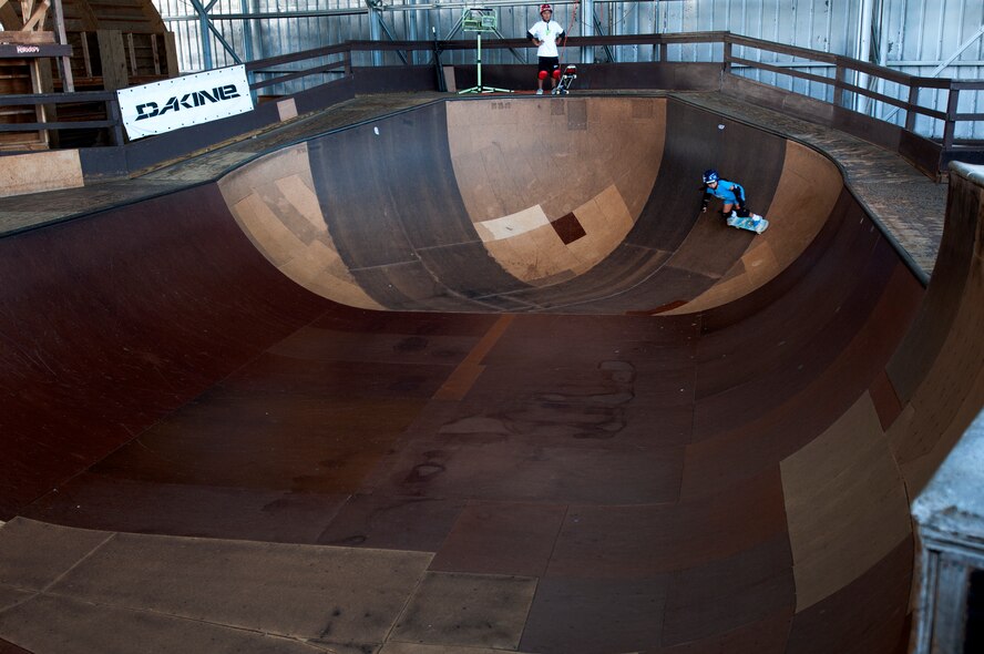 Kody Tamanaha, 8, of Mililani, Hawaii, skates inside a bowl while her brother, Ian, 10, waits his turns at the Hickam Skate Hangar Aug. 16 at Joint Base Pearl Harbor-Hickam, Hawaii. The converted hangar is the only indoor wooden facility on all the Hawaiian Islands. It also boasts the only wooden keyhole bowls, or empty swimming pool shaped ramps, on Oahu. In addition, it has a 15,000 square foot street course, multiple mini ramps, 12-foot vertical ramp with a 14-foot tombstone connected to a saddle and three-quarter pipe. (U.S. Air Force photo/Staff Sgt. Mike Meares)