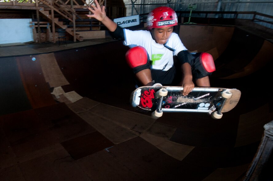 Ian Tamanaha, 10, of Mililani, Hawaii, performs a trick while skating one of the bowls at the Hickam Skate Hangar Aug. 22 at Joint Base Pearl Harbor-Hickam, Hawaii. The converted hangar is the only indoor wooden facility on all the Hawaiian Islands. It also boasts the only wooden keyhole bowls, or empty swimming pool shaped ramps, on Oahu. In addition, it has a 15,000 square foot street course, multiple mini ramps, 12-foot vertical ramp with a 14-foot tombstone connected to a saddle and three-quarter pipe. (U.S. Air Force photo/Staff Sgt. Mike Meares)