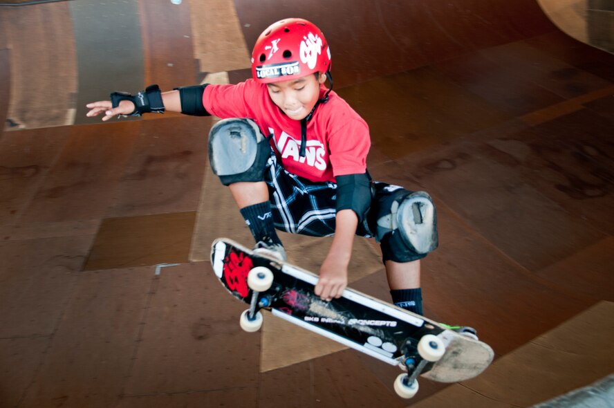Ian Tamanaha, 10, of Mililani, Hawaii, performs a trick while skating one of the bowls at the Hickam Skate Hangar Aug. 16 at Joint Base Pearl Harbor-Hickam, Hawaii. The converted hangar is the only indoor wooden facility on all the Hawaiian Islands. It also boasts the only wooden keyhole bowls, or empty swimming pool shaped ramps, on Oahu. In addition, it has a 15,000 square foot street course, multiple mini ramps, 12-foot vertical ramp with a 14-foot tombstone connected to a saddle and three-quarter pipe. (U.S. Air Force photo/Staff Sgt. Mike Meares)