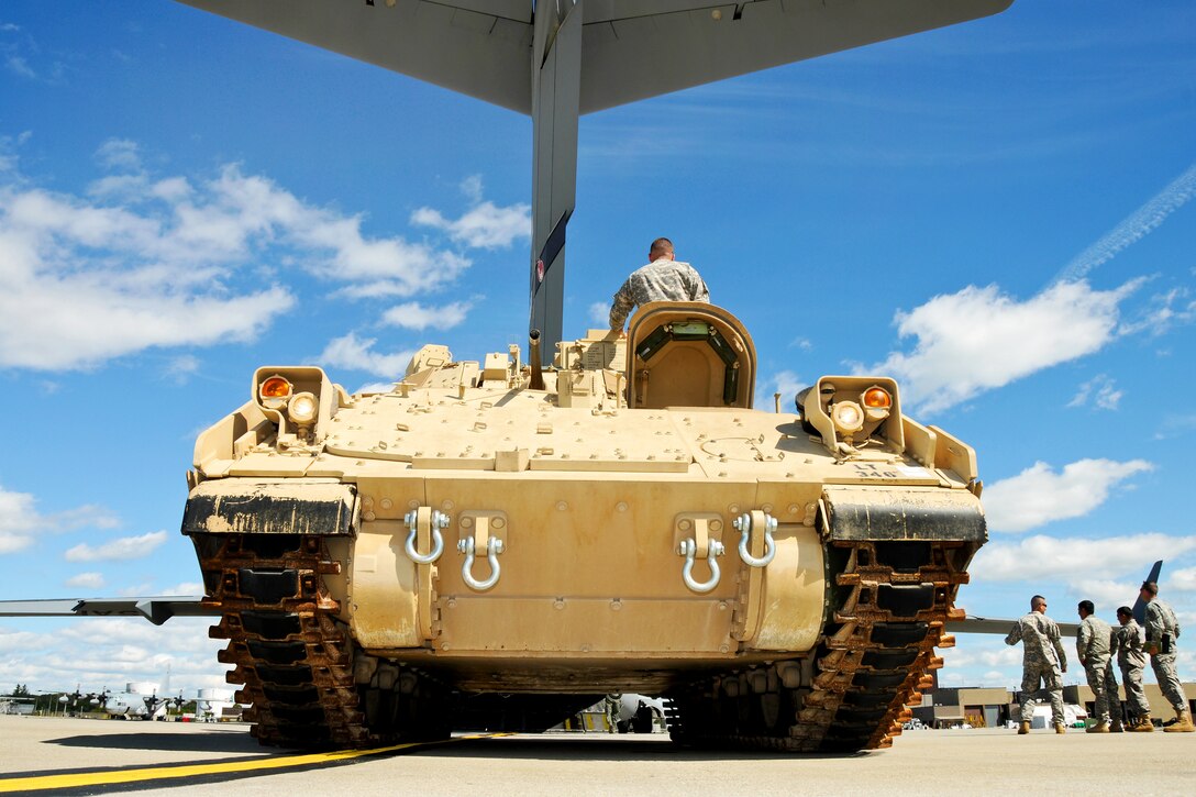 An Army Bradley fighting vehicle driver waits for the load master's guidance on backing his M32A onto a 105th Airlift Wing C-17 Globemaster III on the flightline on Stewart Air National Guard Base, Newburgh, N.Y., Sept. 19, 2012.