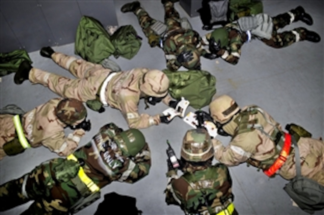 U.S. airmen take cover during a simulated bombing and chemical attack as part of an operational readiness exercise on Royal Air Force Base Mildenhall, England, Sept. 11, 2012. The airmen are assigned to the 100th Civil Engineer Squadron.