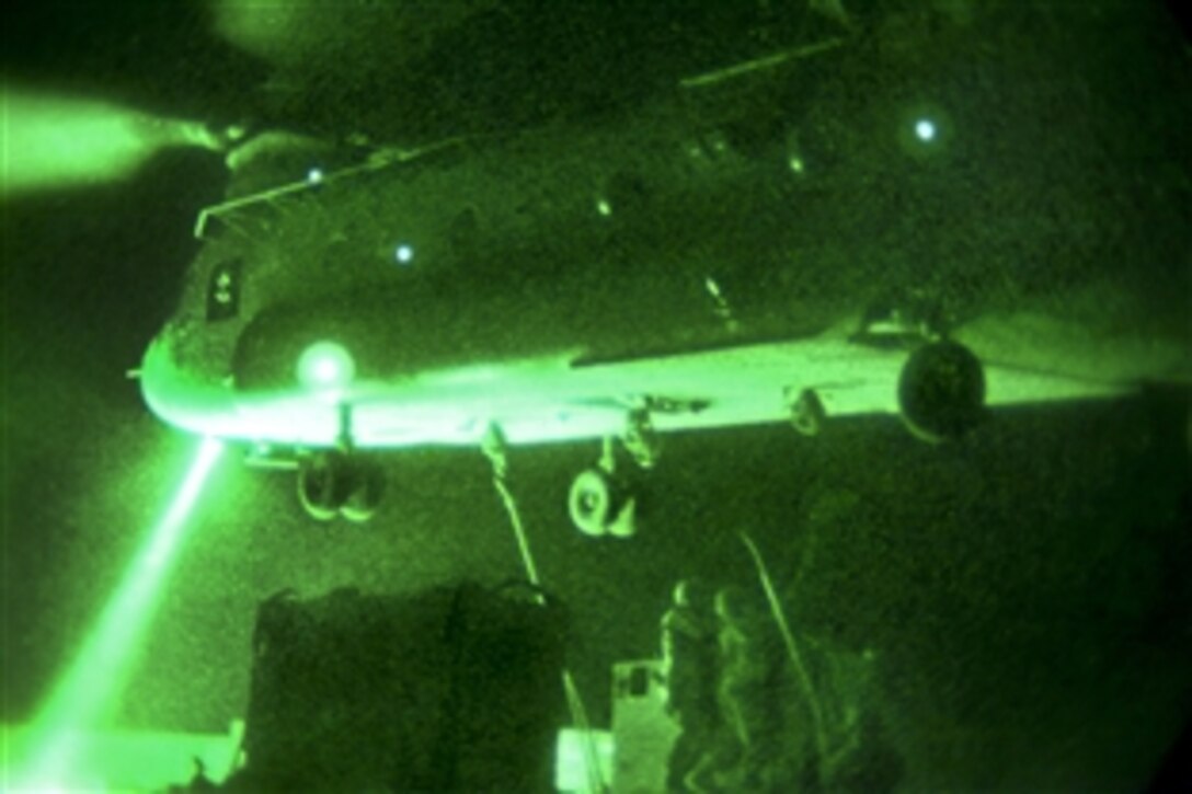 As seen through a night-vision device, U.S. soldiers attach a generator to a CH-47 Chinook helicopter on Forward Operating Base Shank in Afghanistan's Logar province, Sept. 10, 2012.