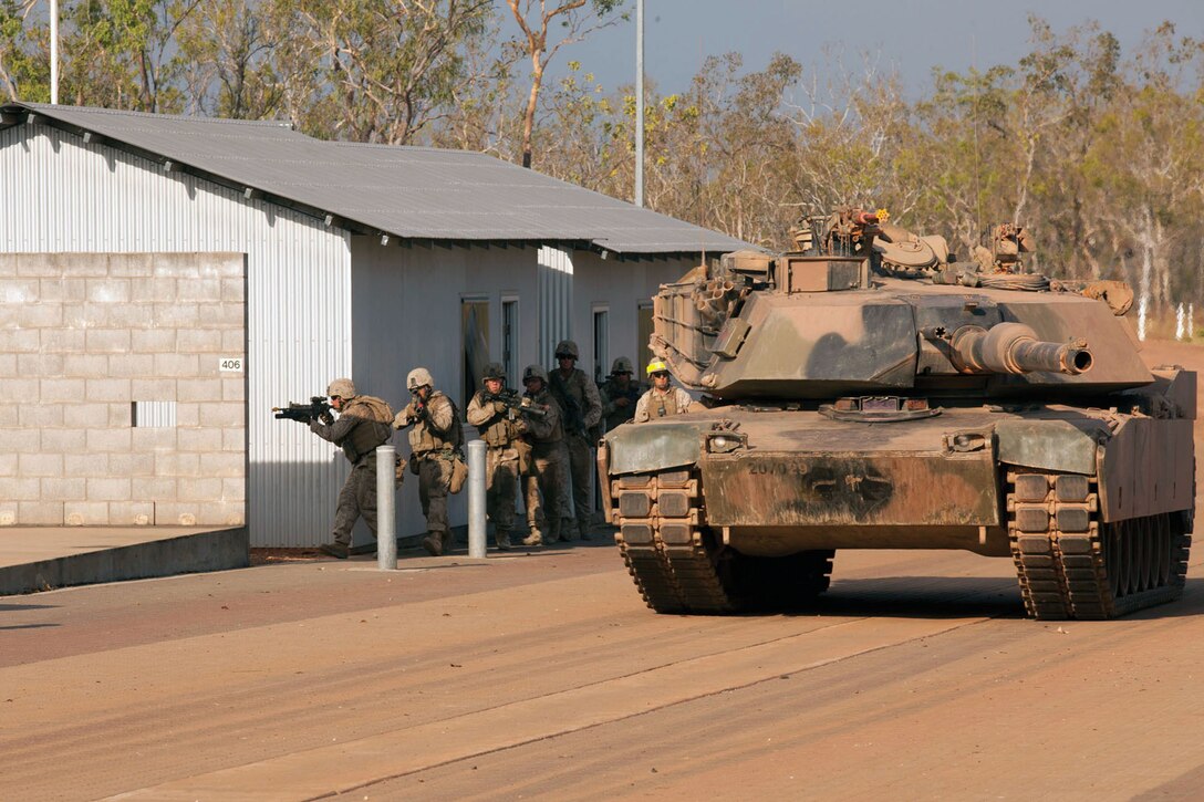 Marines advance alongside an Australian M1A1 tank during a bilateral assault at the urban operations training facility at Mount Bundy Training Area, Northern Territory, Australia, Sept. 5. For approximately three weeks, Marines conducted bilateral field training with various elements of the Australian Army. The tank is assigned to 2nd Troop, A Squadron, 1st Armored Regiment, Australian Army. The Marines are with Company F, 2nd Battalion, 3rd Marine Regiment, 3rd Marine Division, III Marine Expeditionary Force. 