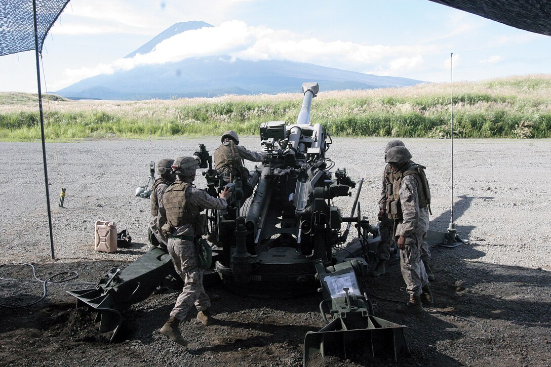 Marines prepare to fire rounds from an M777A2 155 mm howitzer at East Fuji Maneuver Area in mainland Japan Sept. 11. The Marines wait for fire commands from the fire direction center prior to sending rounds downrange. The Marines are with Oscar Battery, 5th Battalion, 14th Marine Regiment, 4th Marine Division, assigned to 3rd Battalion, 12th Marines, 3rd Marine Division, III Marine Expeditionary Force, under the unit deployment program. 