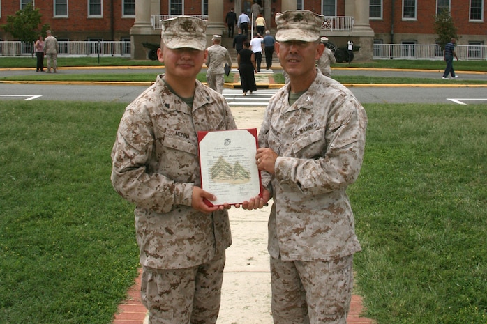 Colonel Andy Bianca (right), Marine Corps Systems Command’s Program Manager for Infantry Weapon Systems, presents Corporal Andres Medina with his promotion warrant in early September