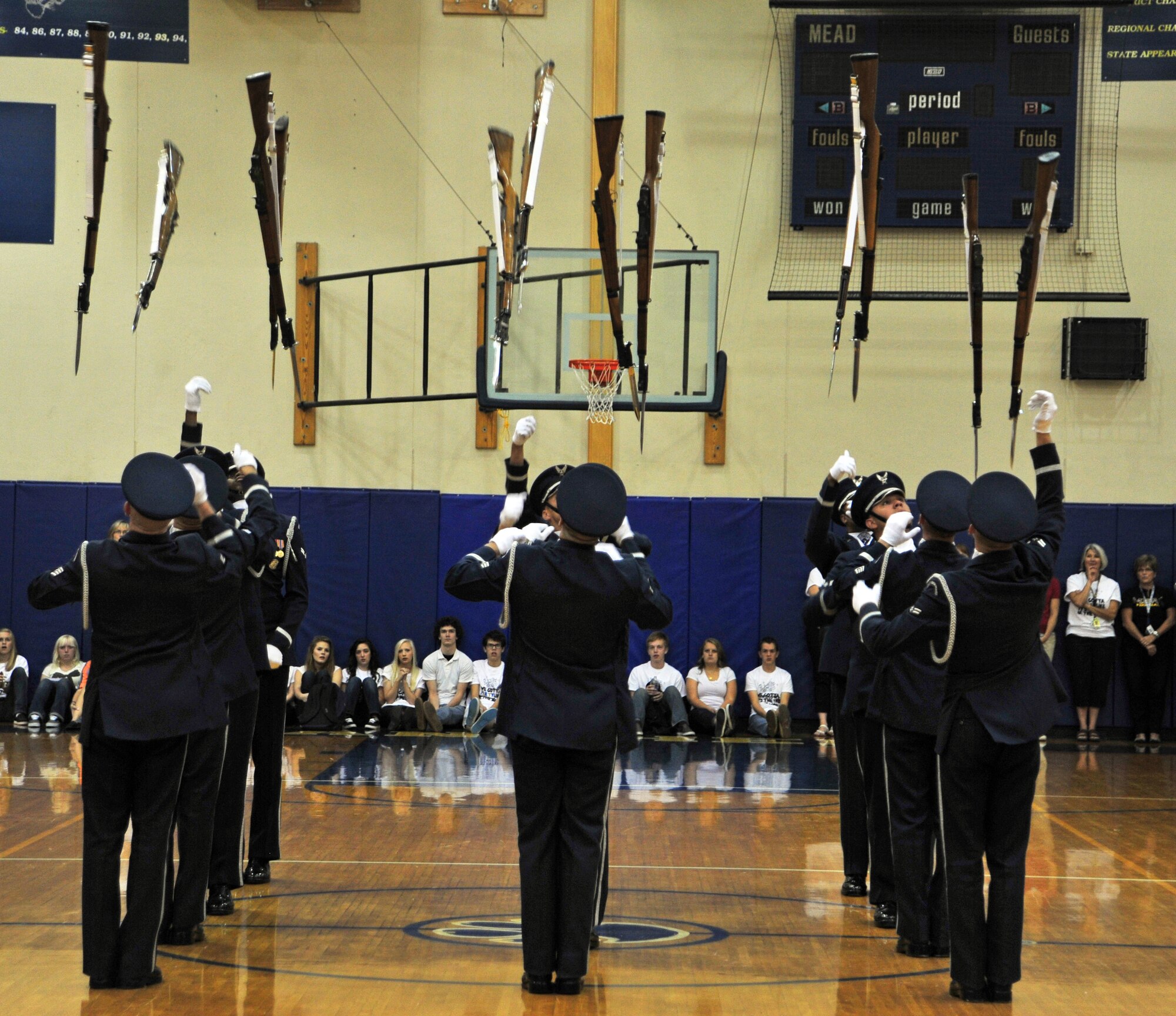 U.S. Air Force Honor Guard drill team members simultaneously throw all their rifles above their heads during a performance at Rogers High School, Spokane, Wash., Sept. 19, 2012. The primary mission of the U.S. Air Force Honor Guard is to represent Airmen to the American public and the world. (U.S. Air Force photo by Airman 1st Class Taylor Curry)