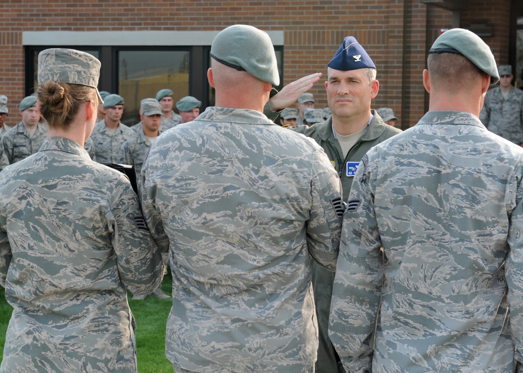 Col. Brian Newberry, 92nd Air Refueling Wing commander, renders a salute to the colors presented by Staff Sgt. Elcke Fromm, 336th Training Group commander's support staff, Tech Sgt. Brandon Biddle, 22nd Training Squadron Survival Evasion Resistance Escape specialist, and Senior Airman Anthony Pinque, 22nd TRS SERE specialist, during a Retreat Ceremony honoring prisoners of war and those missing in action at Fairchild Air Force Base, Wash. Sept. 21, 2012. The ceremony was held at the 336th Training Group headquarters building flagpole. (U.S. Air Force photo by Staff Sgt. Michael Means)