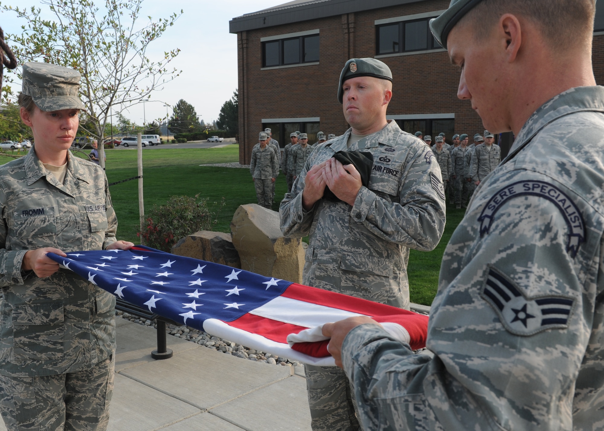 Staff Sgt. Elcke Fromm, 336th Training Group commander's support staff, Tech Sgt. Brandon Biddle, 22nd Training Squadron Survival Evasion Resistance Escape specialist, and Senior Airman Anthony Pinque, 22nd TRS SERE specialist, perform a flag folding during a Retreat Ceremony honoring prisoners of war and those missing in action at Fairchild Air Force Base, Wash. Sept. 21, 2012. The National POW/MIA Recognition Day is a day of observance for all Ameicans to pause in remembrance of the sacrifices and service of those who are missing in action. (U.S. Air Force photo by Staff Sgt. Michael Means)