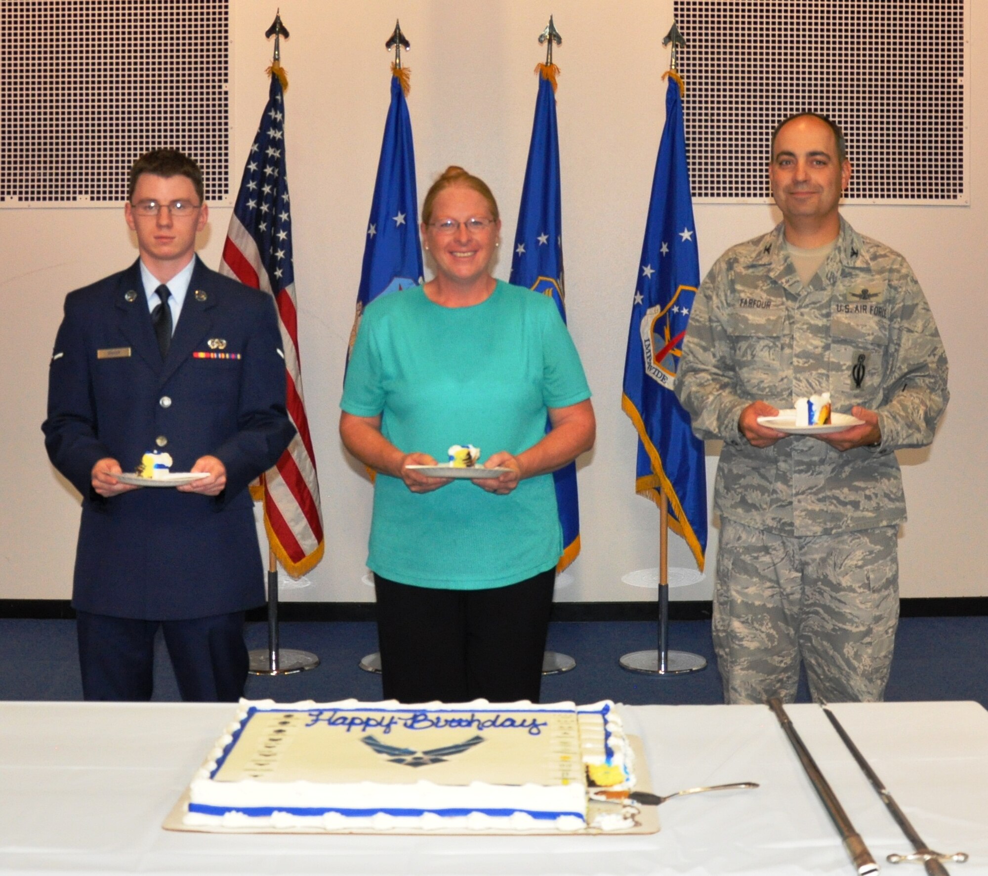 Col. George Farfour, 90th Missile Wing vice commander, Ms. Elaine Hart, 90th Missile Wing Legal Office, and Amn John Baker, 90th Communications Squadron, pose with their pieces of the Air Force Birthday Cake during a celebration commemorating the 65th Air Force Birthday, Sept. 17, at the Fall Hall Community Center on F. E. Warren Air Force Base, Wyo. (U.S. Air Force photo/Staff Sgt. Torri Savarese)