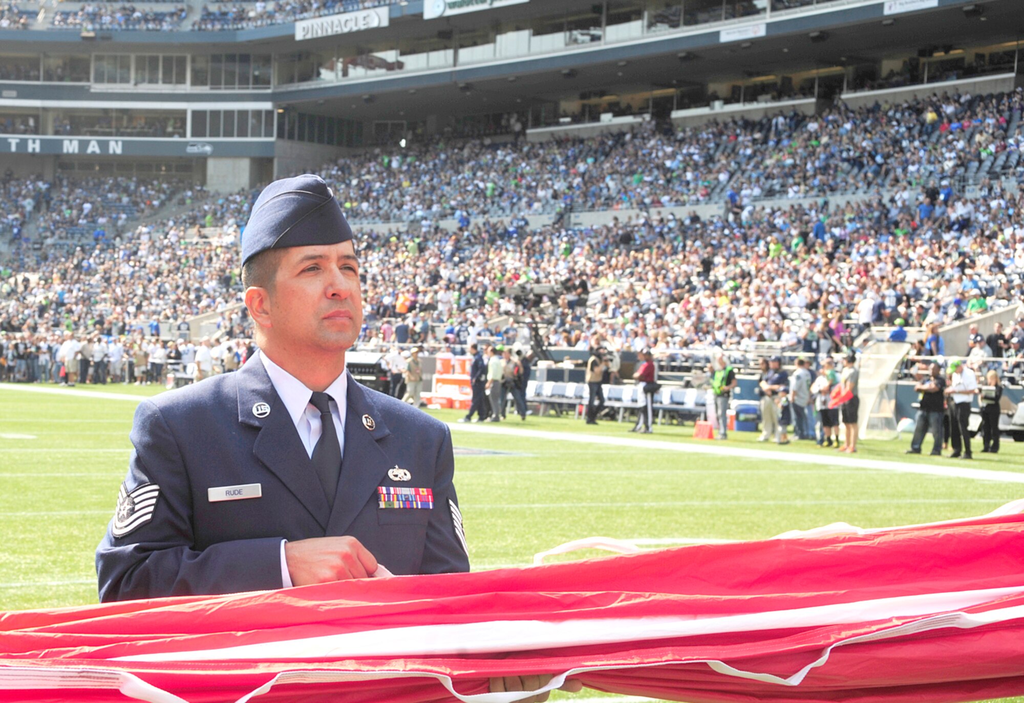 Tech Sgt. Stephan Rude, 446th Maintenance Squadron, was one of more than 30 U.S. Air Force Airmen from the 62nd and 446th Airlift Wings presenting the U.S. flag on the field during pregame ceremonies for the Sept. 16, Seattle Seahawks home opener against the Dallas Cowboys at Century Link field in Seattle. This was the first of three opportunities for the two units to work together in support of the Seattle Seahawks for the 2012 National Football League season. (U.S. Air Force photo by Master Sgt. Todd Wivell)