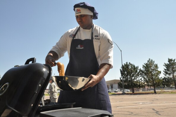 Senior Airman Jamall St. Rose, 320th Missile Squadron chef, places chicken on the grill during the 90th Operations Group Top chef competition Sept. 18. (U.S. Air Force photo by Senior Airman Mike Tryon)