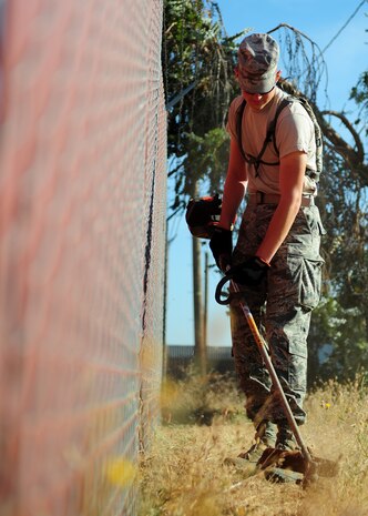 Airman 1st Class Michael Carlsen, 9th Civil Engineer Squadron heavy equipment operator, weed eats around the 9th CES compound Beale Air Force Base, Calif., Sept. 21, 2012. Carlsen participated in Beale Pride Day to clean up base facilities which were previously maintained by contractors. (U.S. Air Force photo by Senior Airman Shawn Nickel/Released)